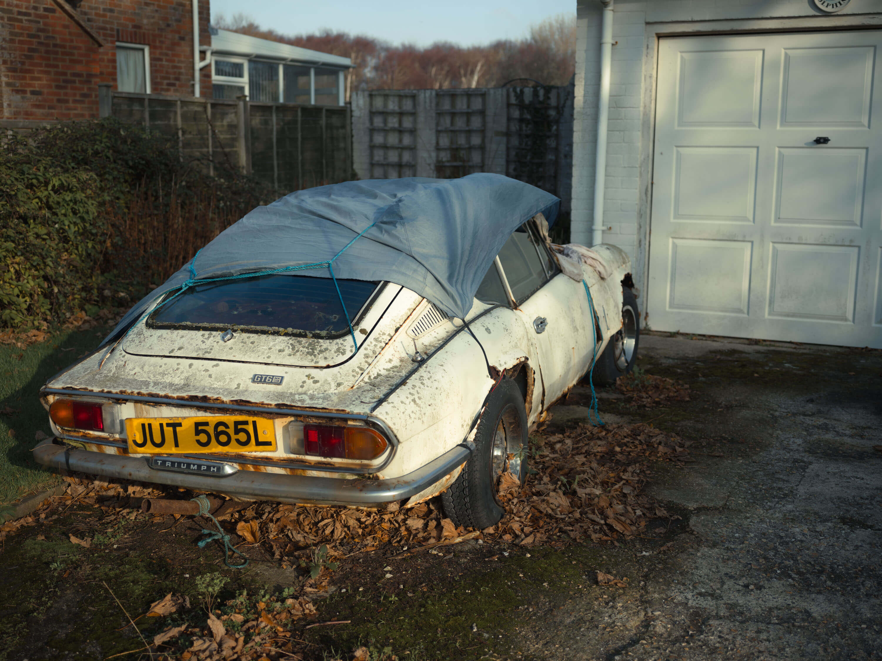 old broken down car outside house 2