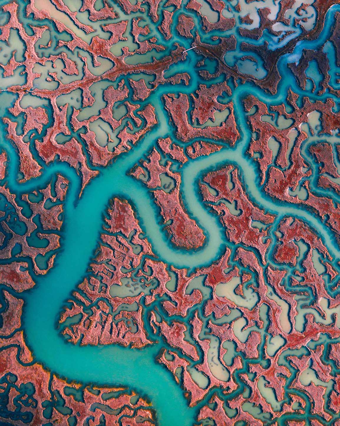 A drone shot of a big network of rivers with bright blue water. 