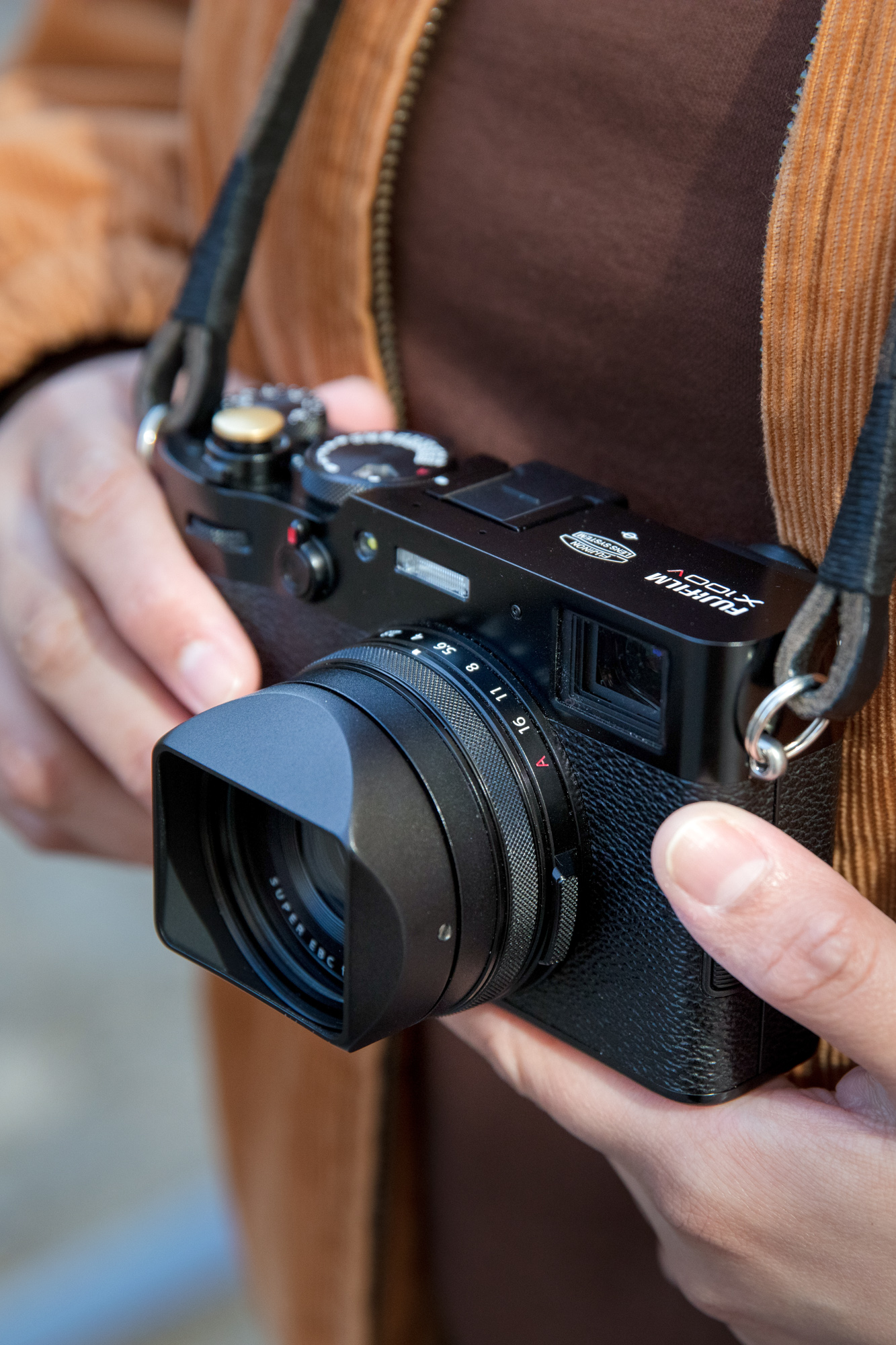 Eine Nahaufnahme der Hände eines Fotografen, der eine Fujifilm X100V hält