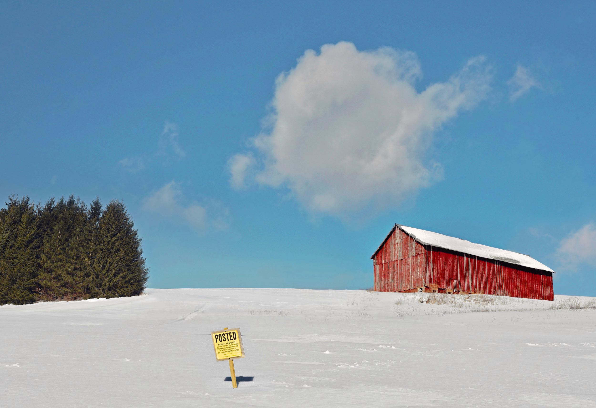 Snowy hill, with a barn at the top.