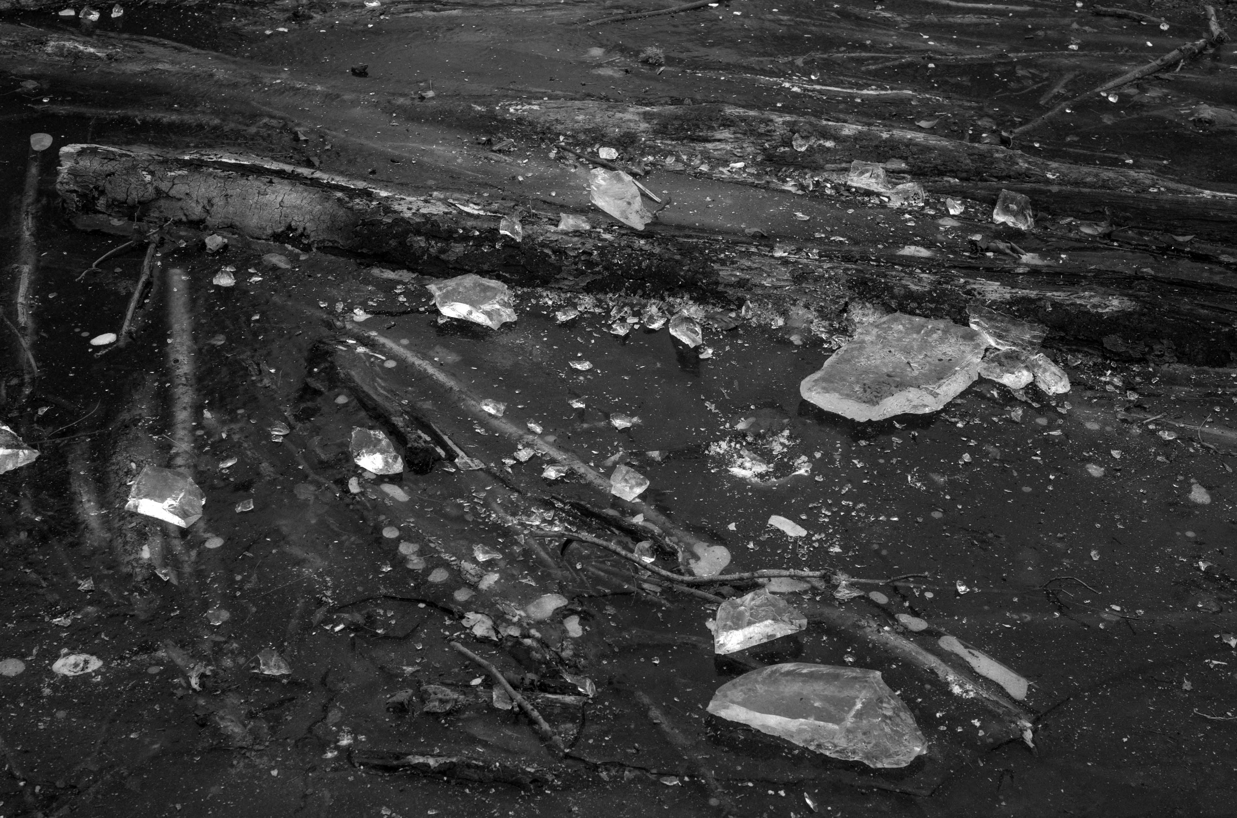 Une photo en noir et blanc de morceaux de glace brisée sur un étang glacé, prise avec un Leica M10 Monochrom.
