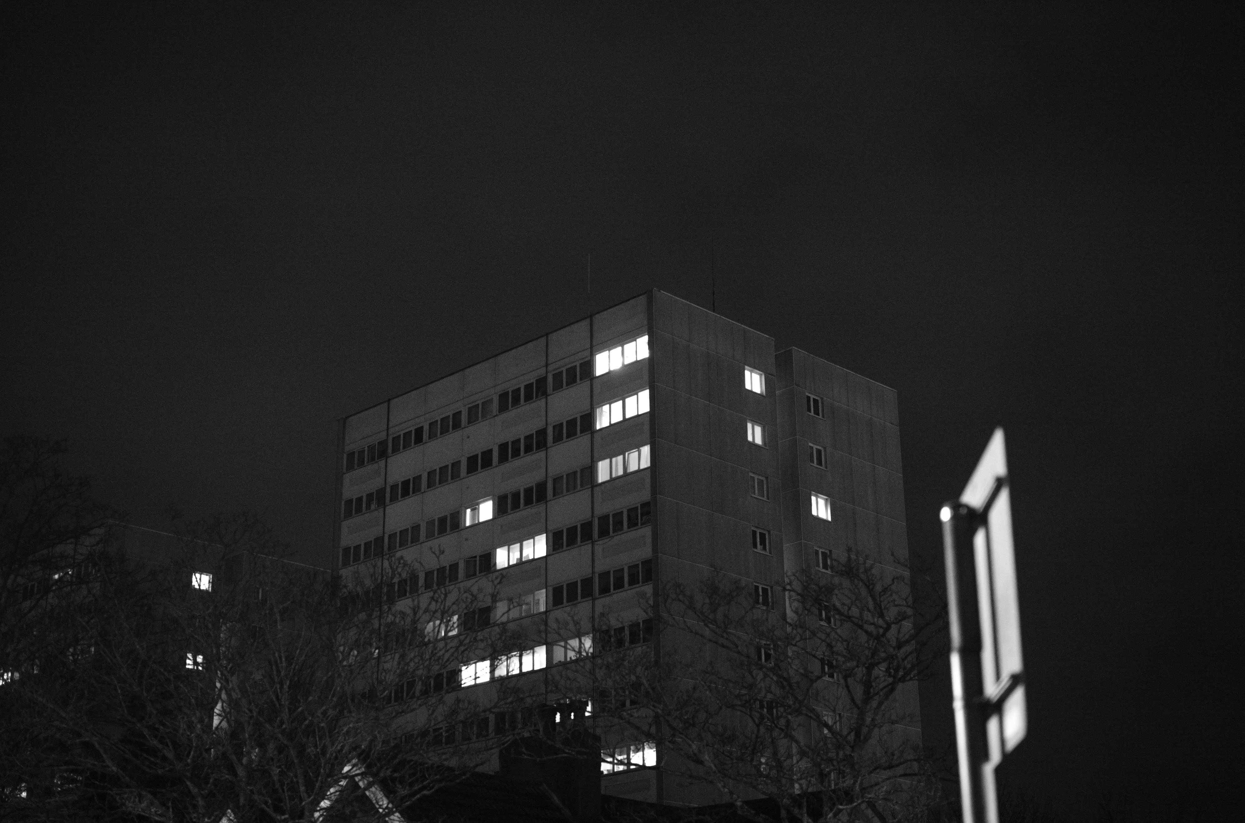 Photo en noir et blanc d'une tour d'habitation de nuit, quelques fenêtres sont éclairées, prise avec un Leica M10 Monochrom à 40 000 ISO.
