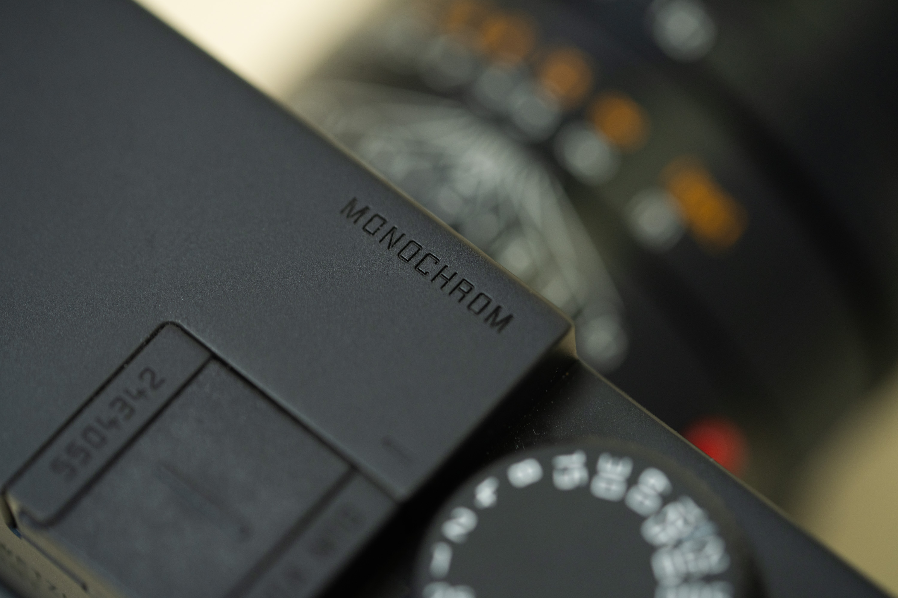 Une photo en gros plan du Leica M10 Monochrom, mettant l'accent sur le mot "Monochrom" gravé sur la plaque supérieure de l'appareil.