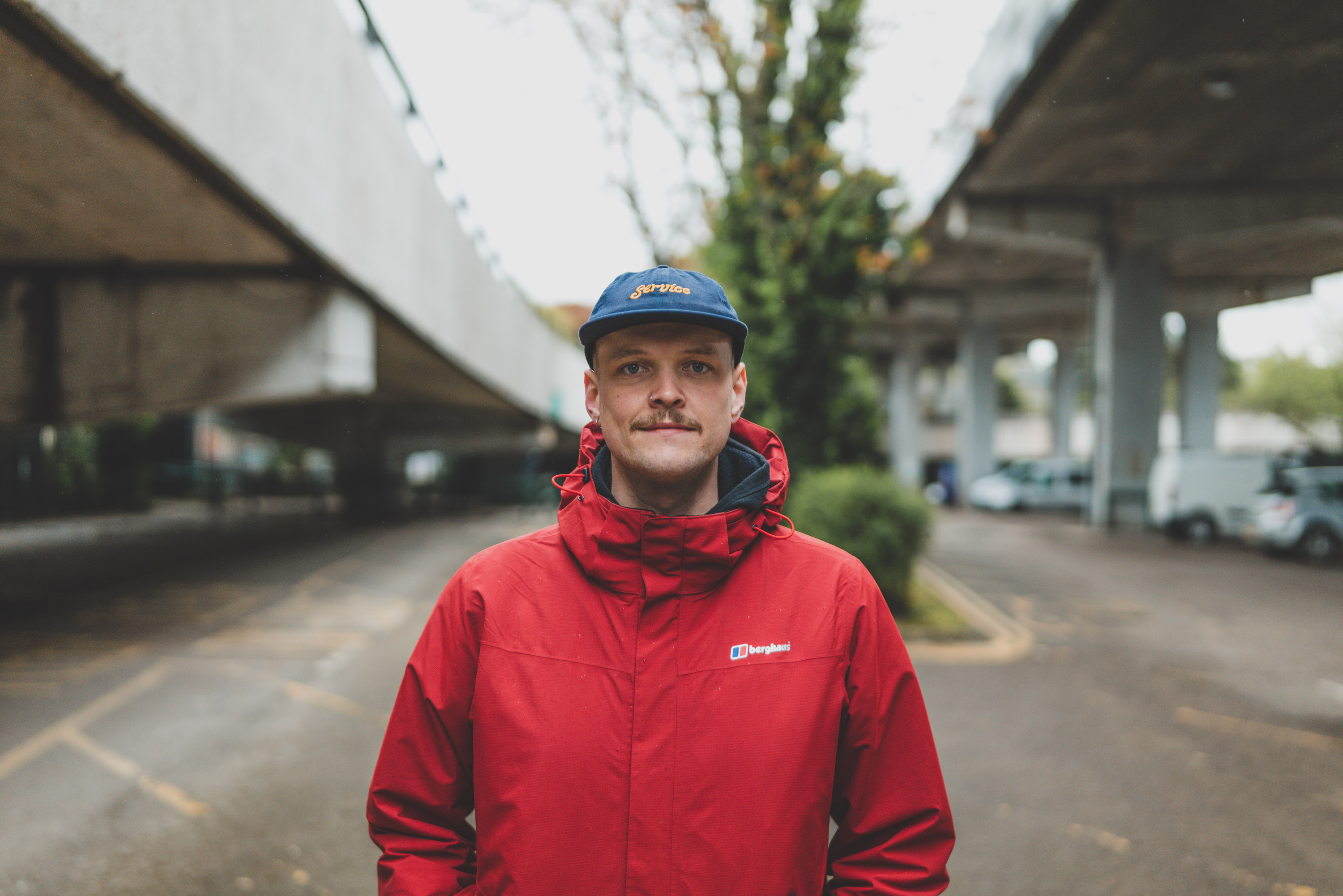 Portrait of a person with blue cap and red raincoat, by Ian Howorth with Leica SL2 and Sigma 35mm f/1.2 DG DN ART