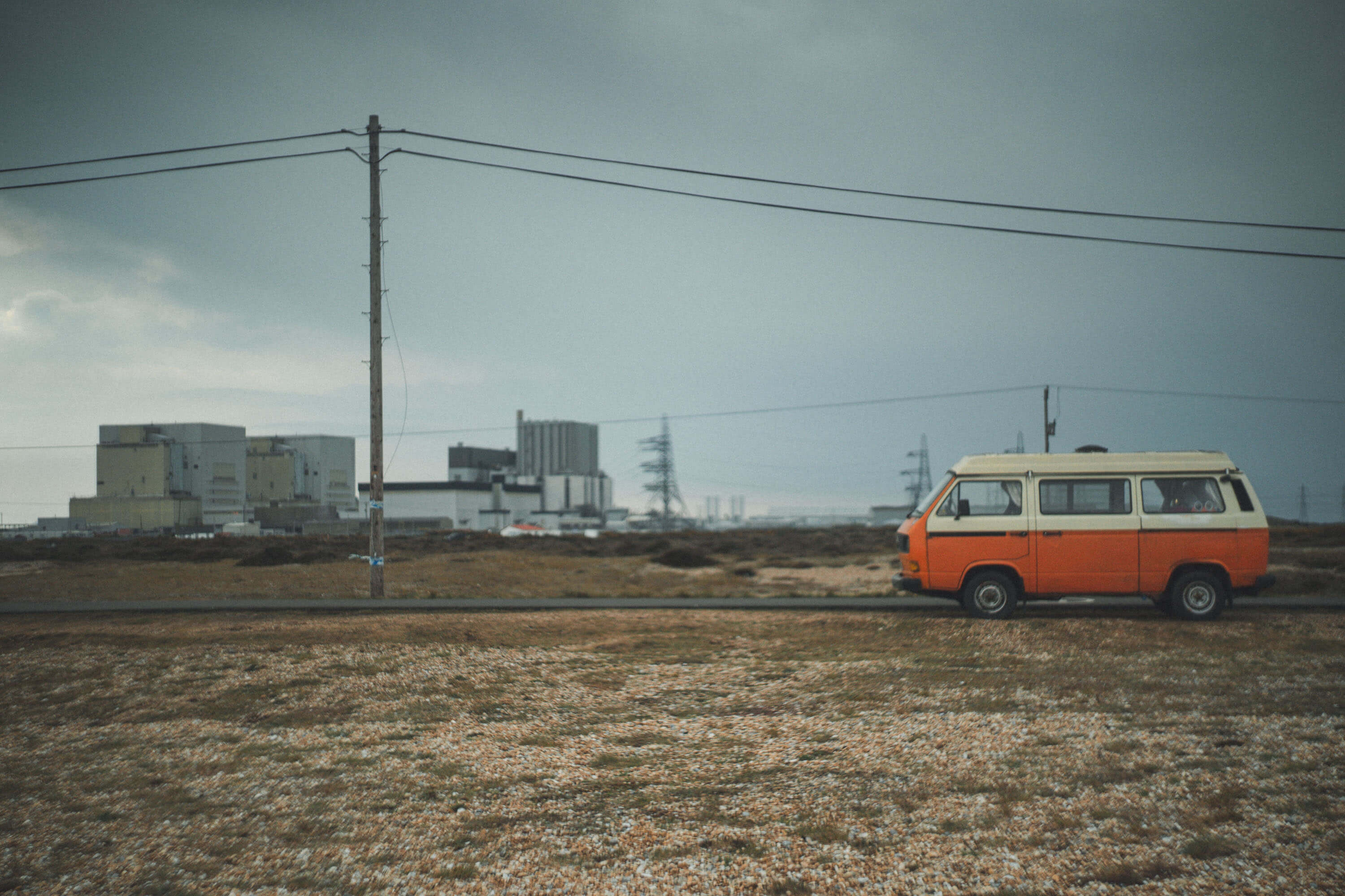 Orange VW Camper Van, with an industrial unit in the background
