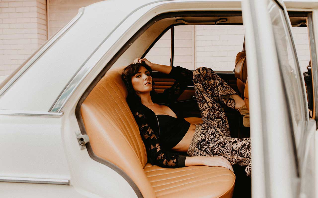 Woman posing in the back of a car