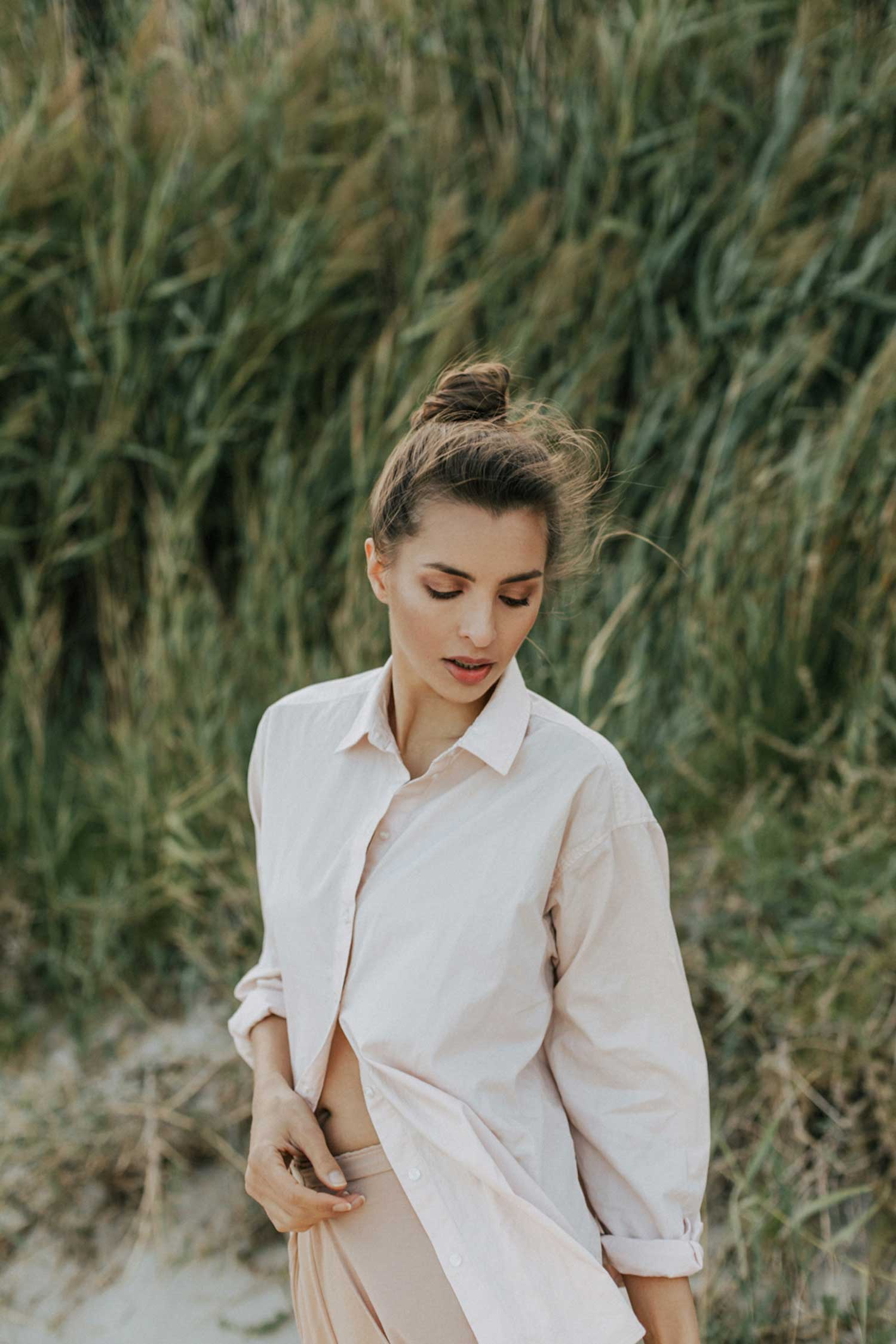 Woman on beach posing, looking down