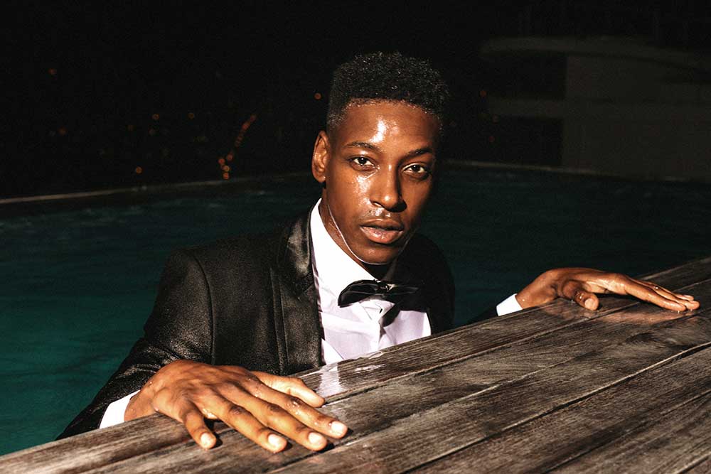 Person in a pool wearing a full suit and tie