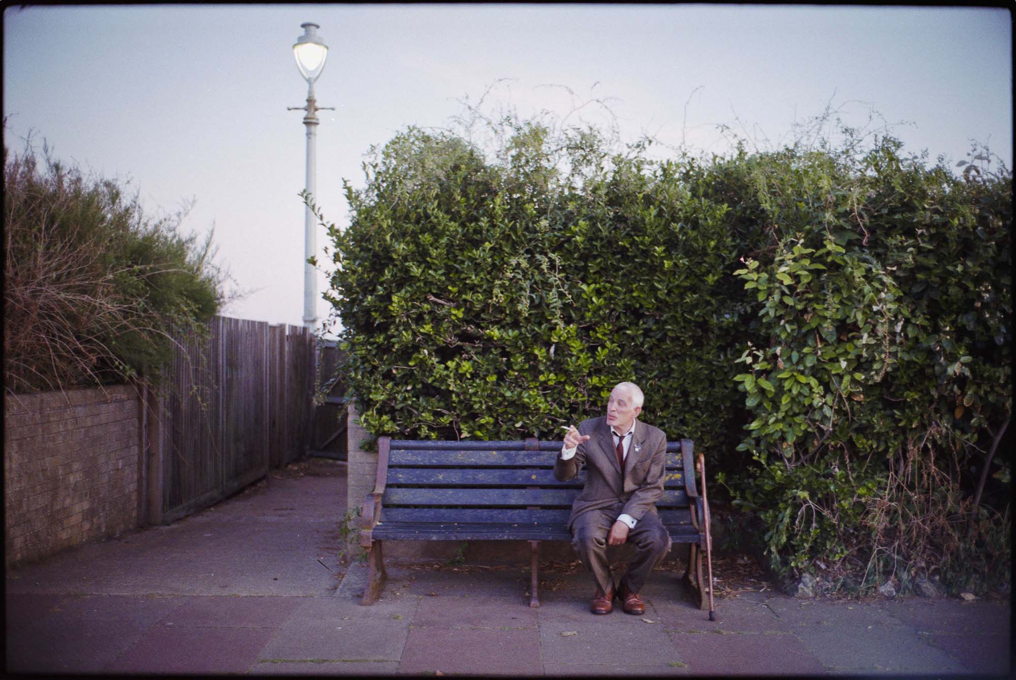 Man sitting on park bench- Brighton