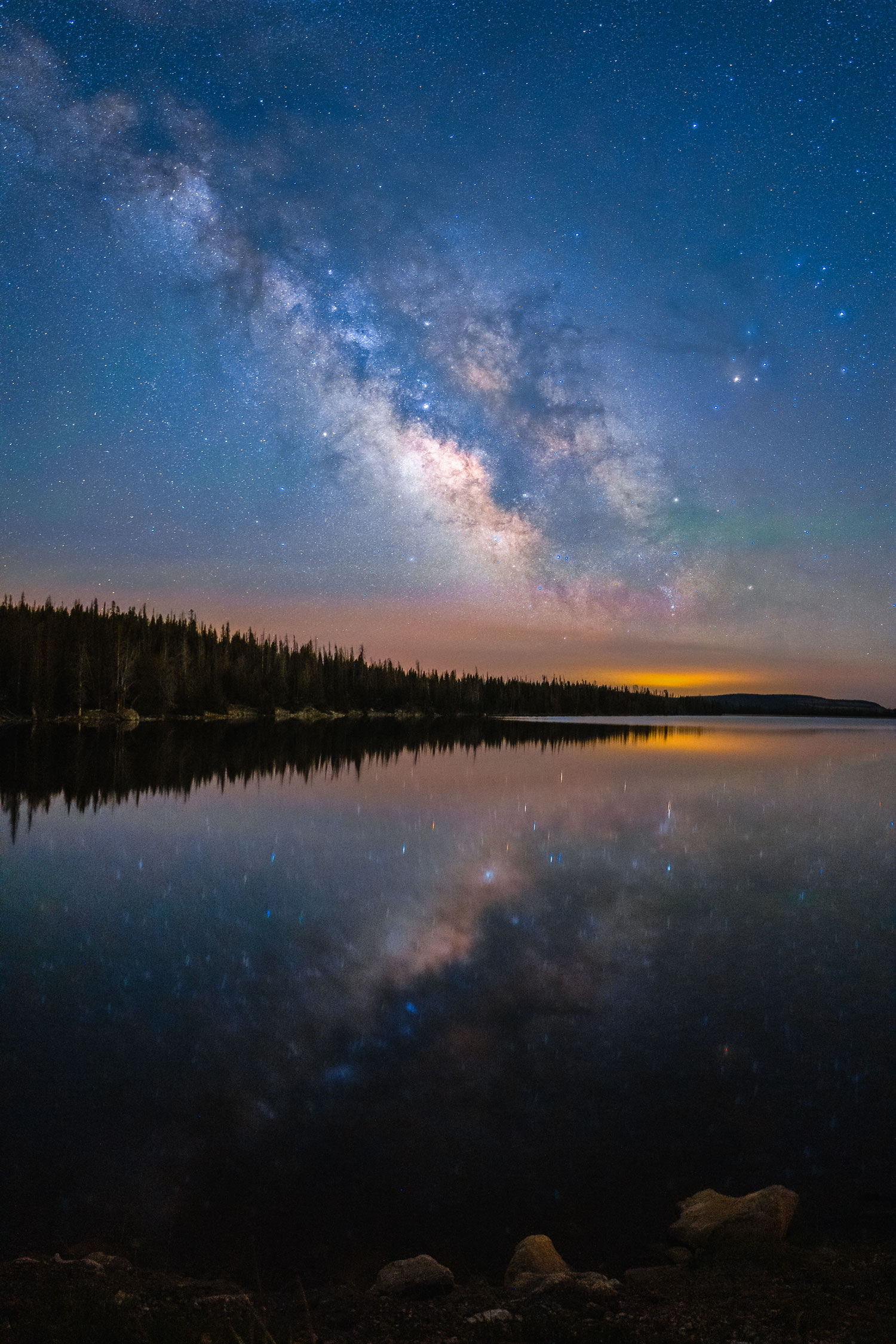 Milky Way over a lake flanked by trees