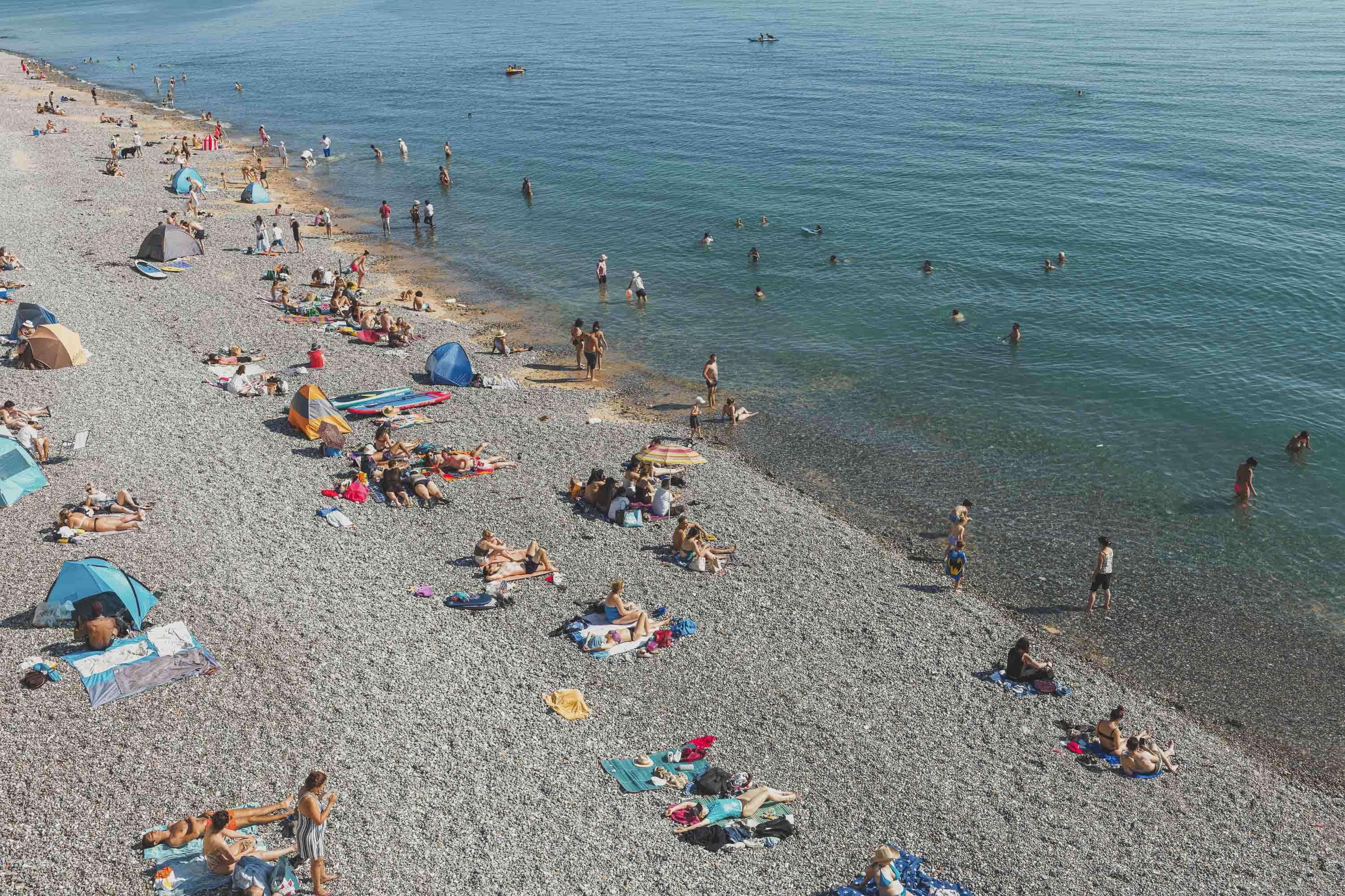Pebbly beach full of people 