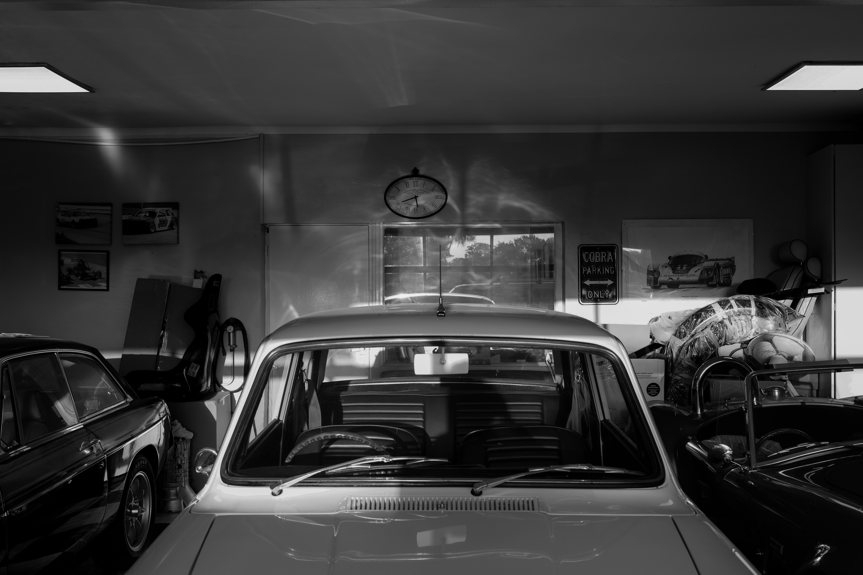Black and White image of the back of a car in a garage 