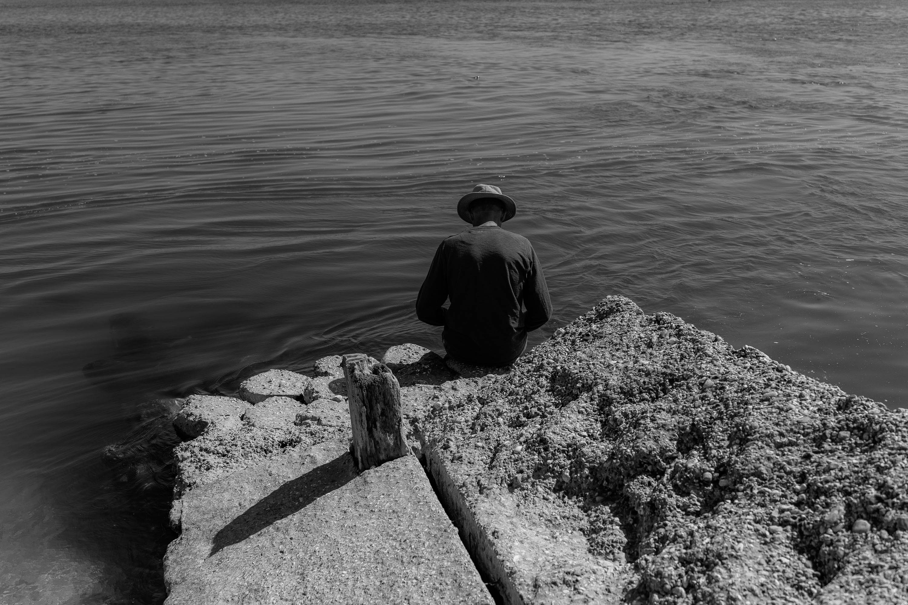Person sitting on the edge of a rocky outcropping