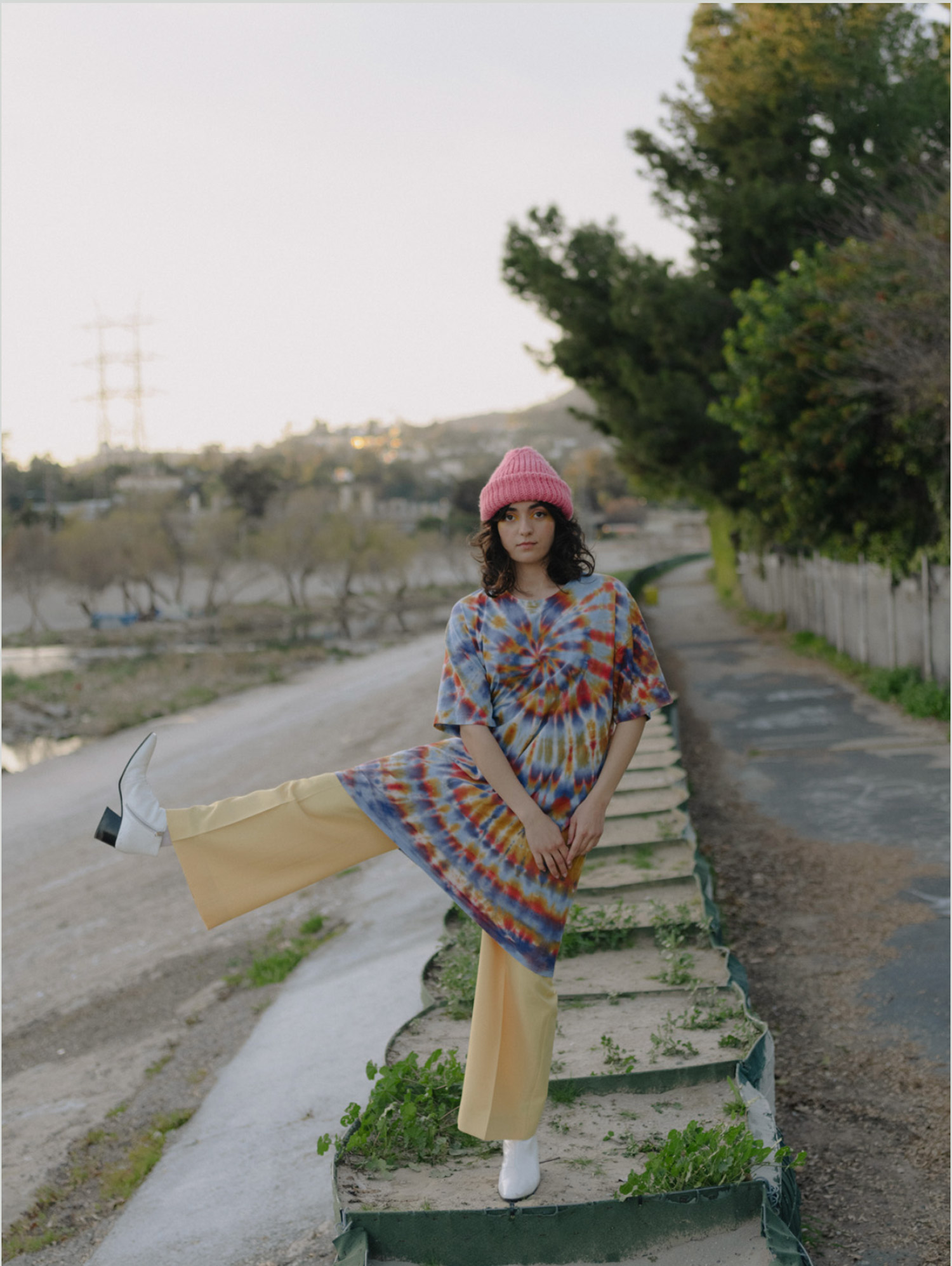 Person wearing a tie-dyed dress in a concrete landscape 