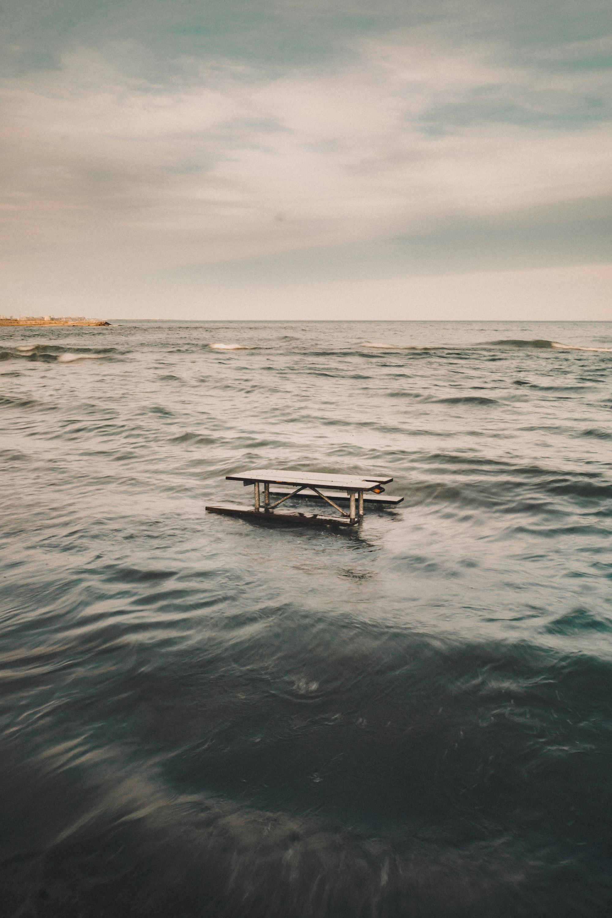 Wooden bench in the middle of the sea on the coast