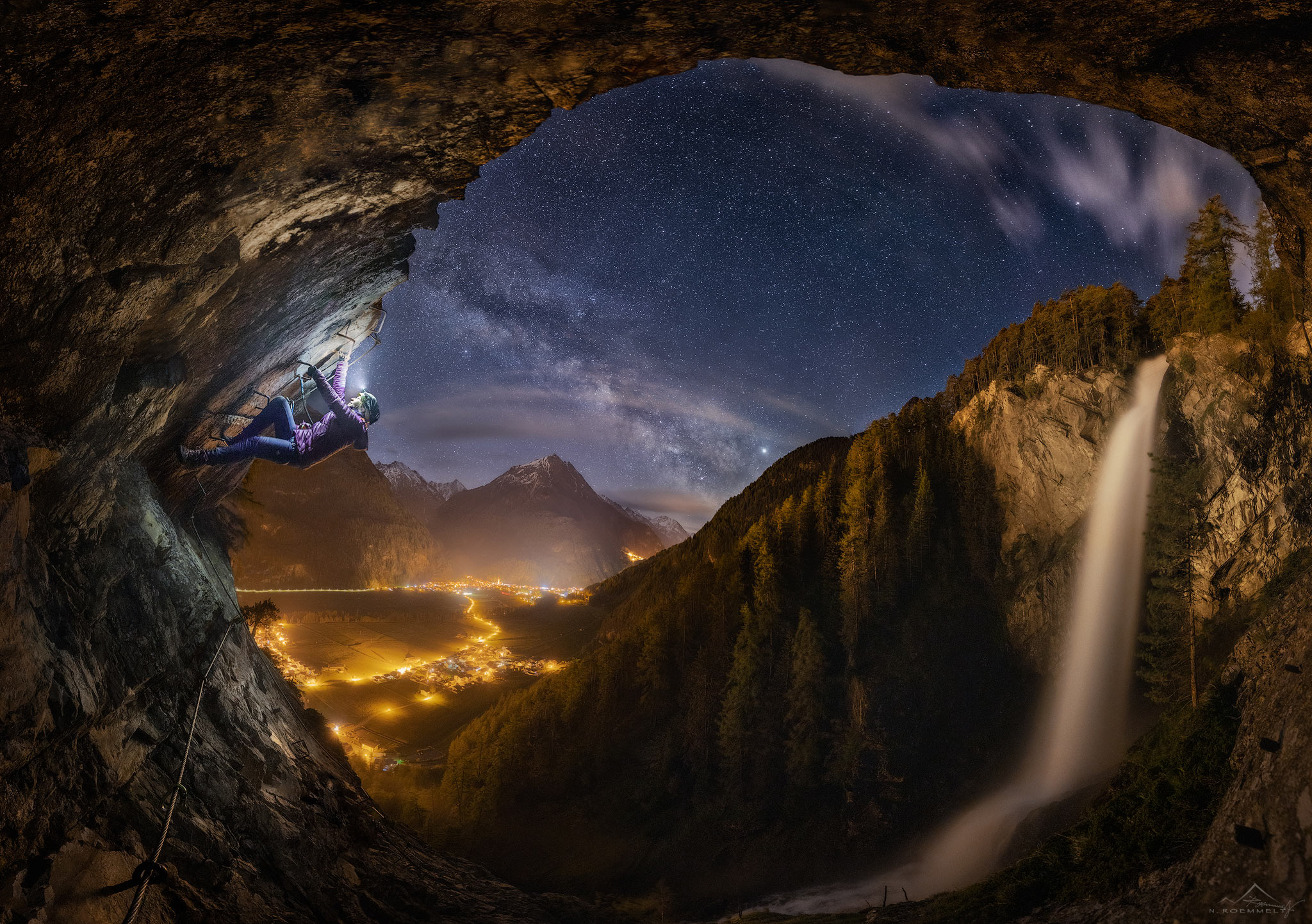 A picture of a woman climbing in a cave in the clear starry sky