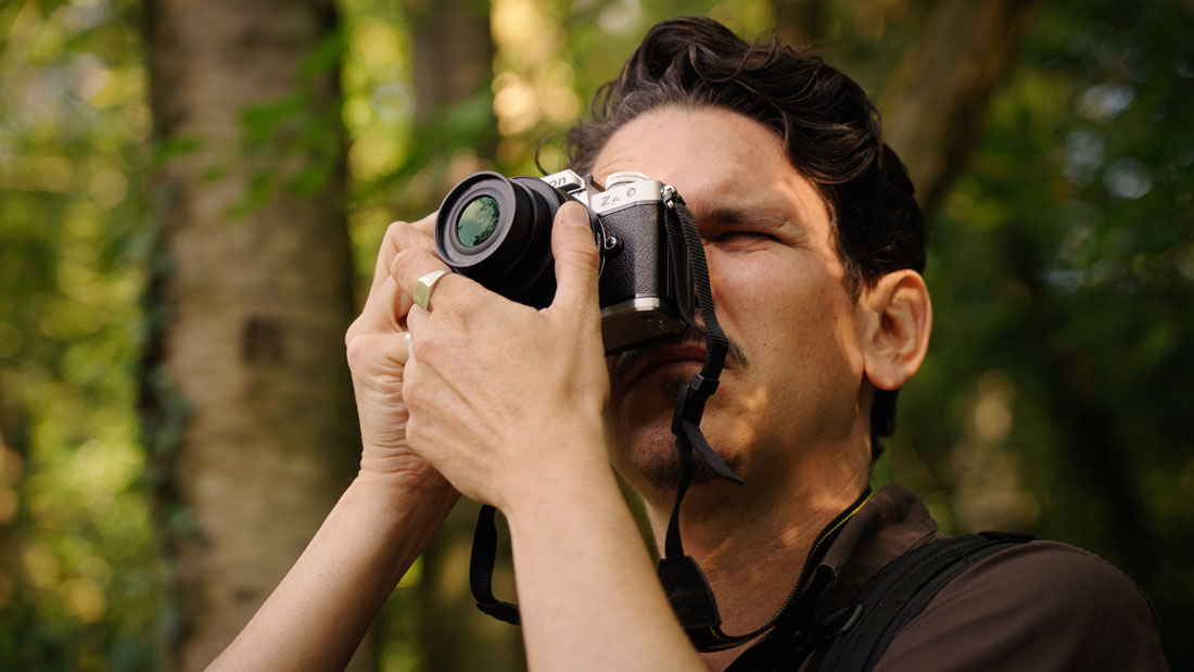 Person taking a picture with a Nikon ZFC