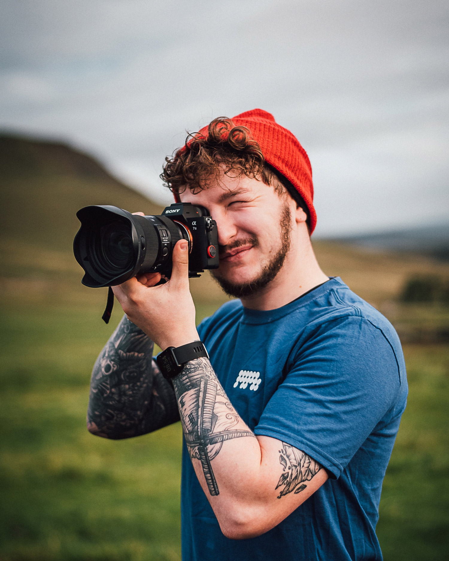 Person taking a picture while smiling. Brendan Clayton @explorewithbrendan.