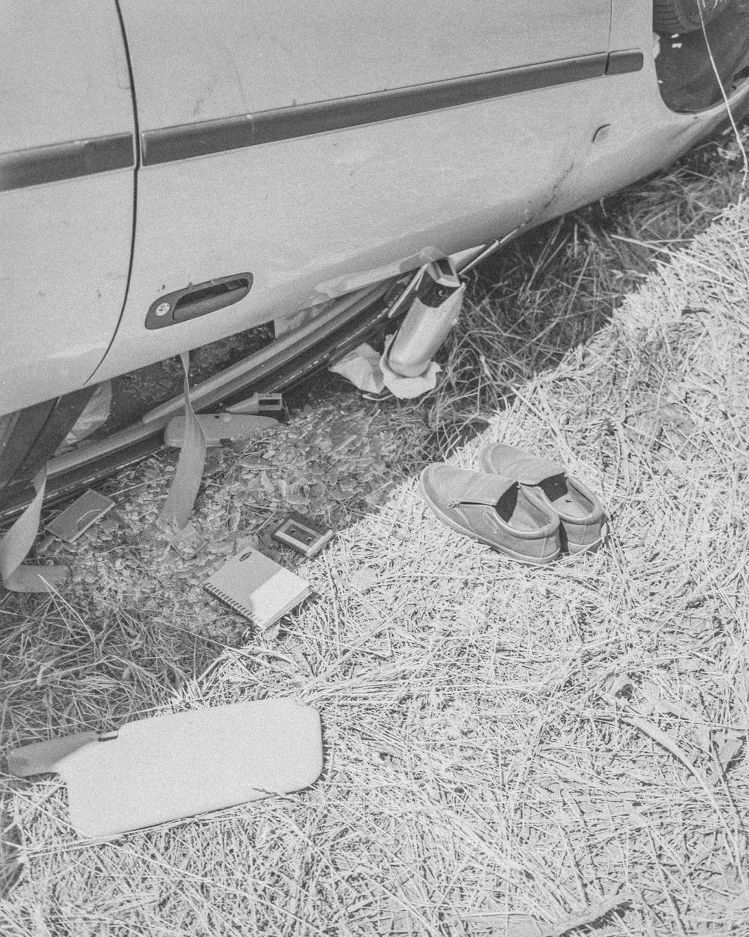 Upside down crashed car with shoes neatly placed by it 