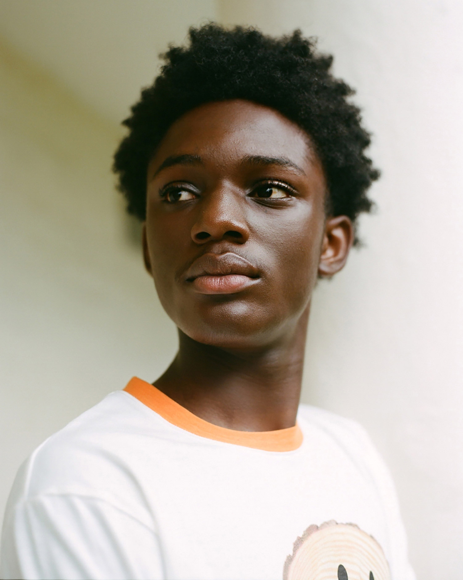 Portrait of a person wearing a white and orange t-shirt