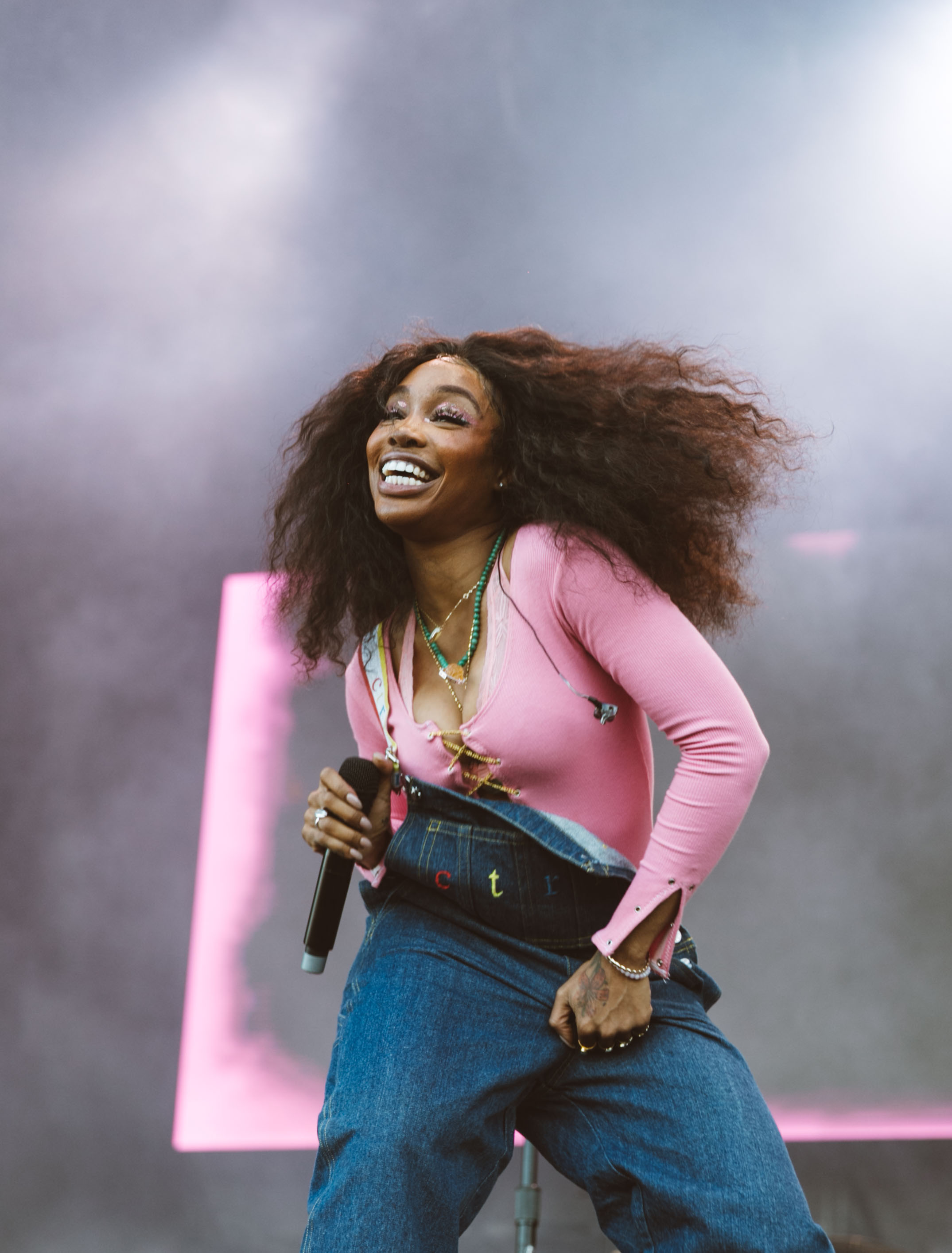 SZA smiling while performing live