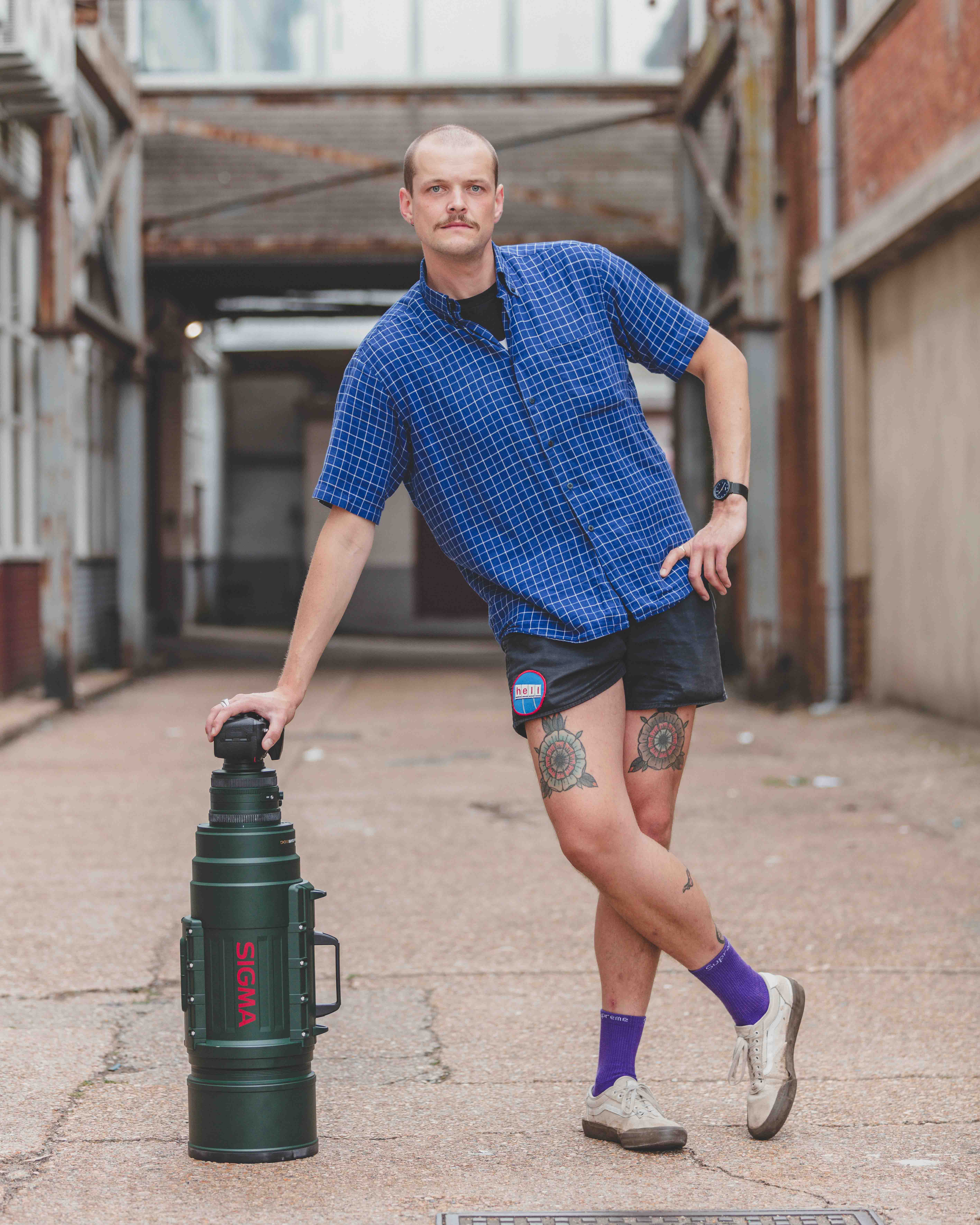 A person leaning on a large camera lens