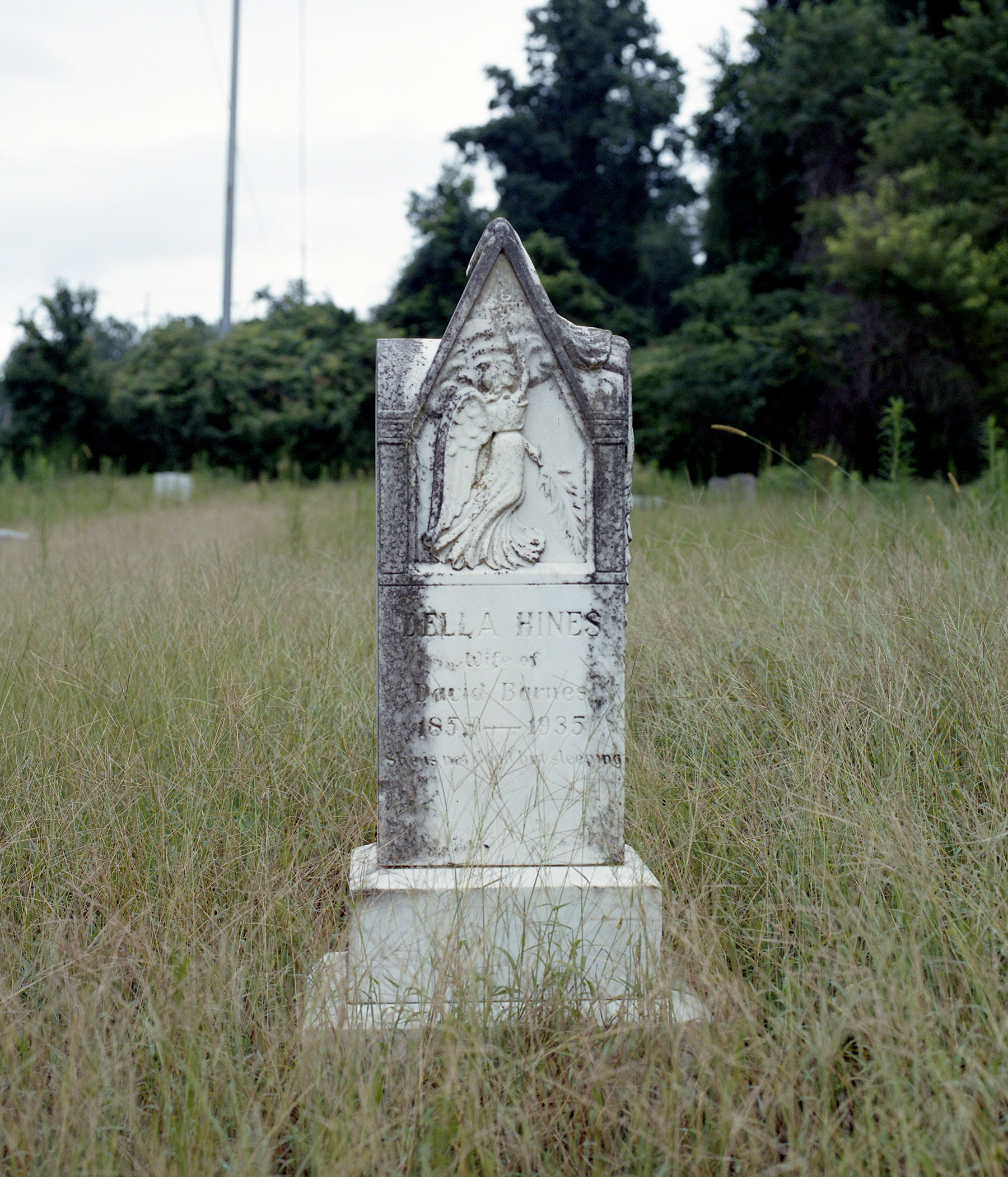 Tombstone in the middle of a grassy field