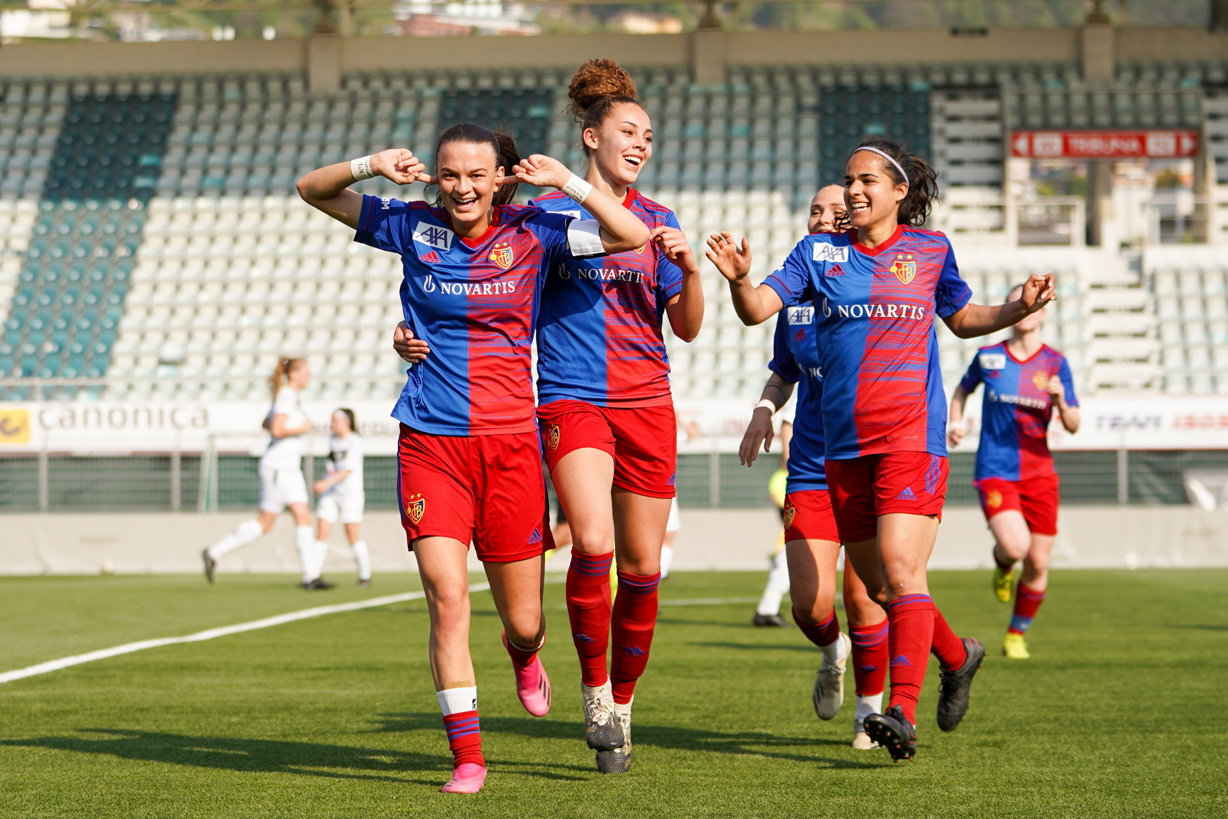 Speelsters van FC Basel Vrouwen lopen en praten op het veld terwijl ze glimlachen