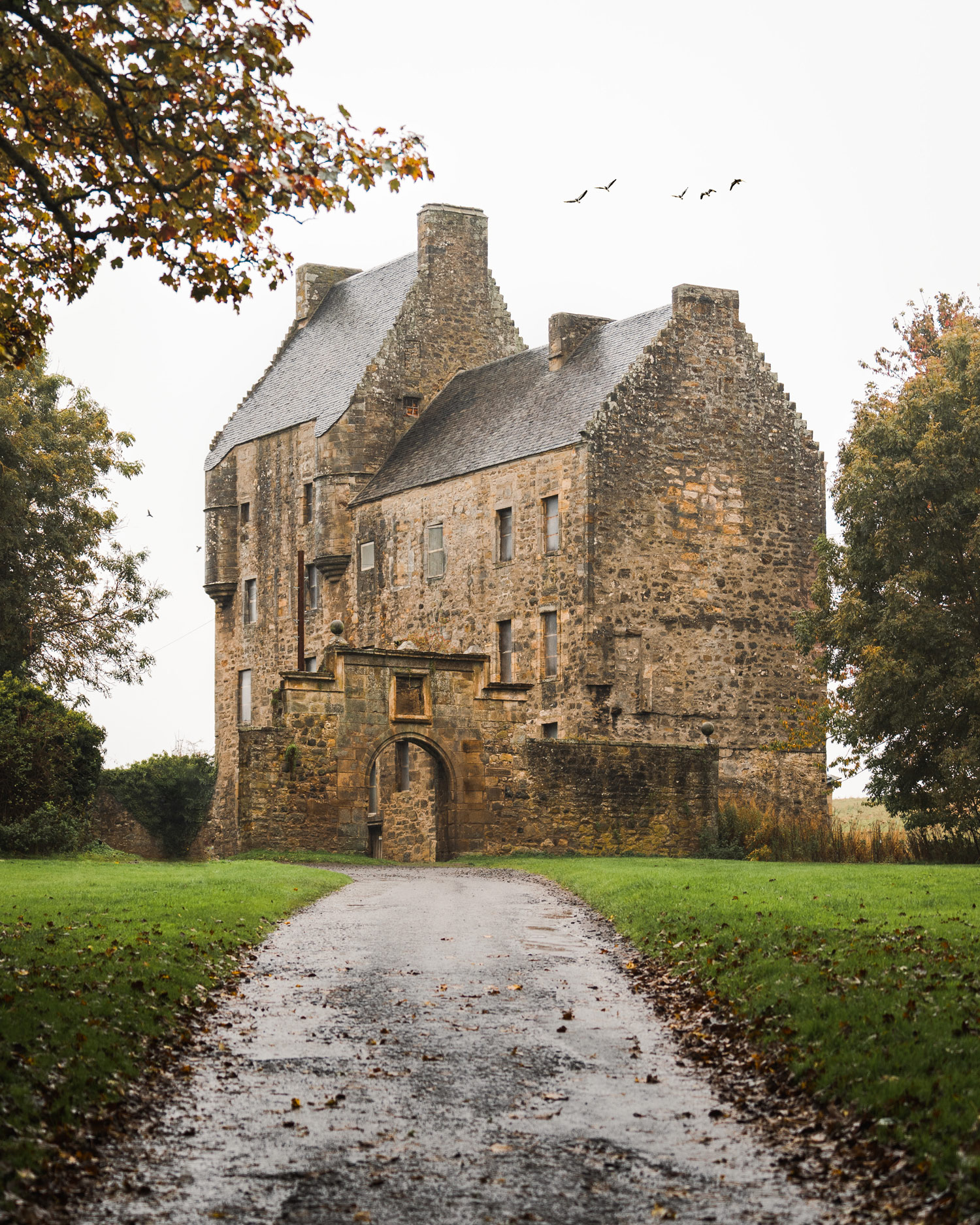 a pathway to a manor house in the distance