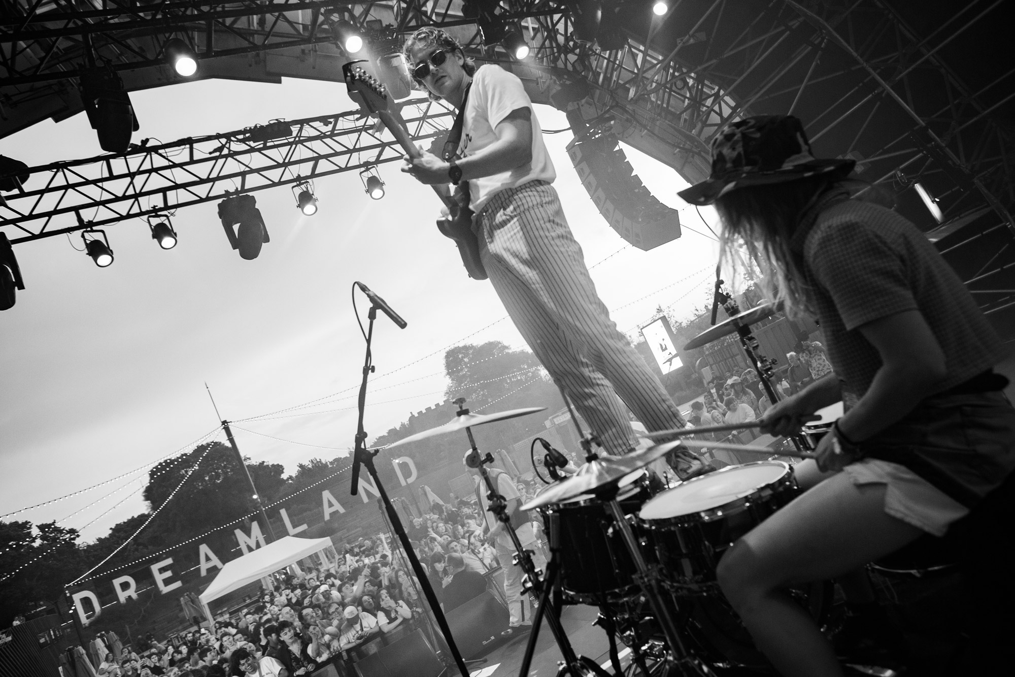 A man playing guitar at a festival in black & white