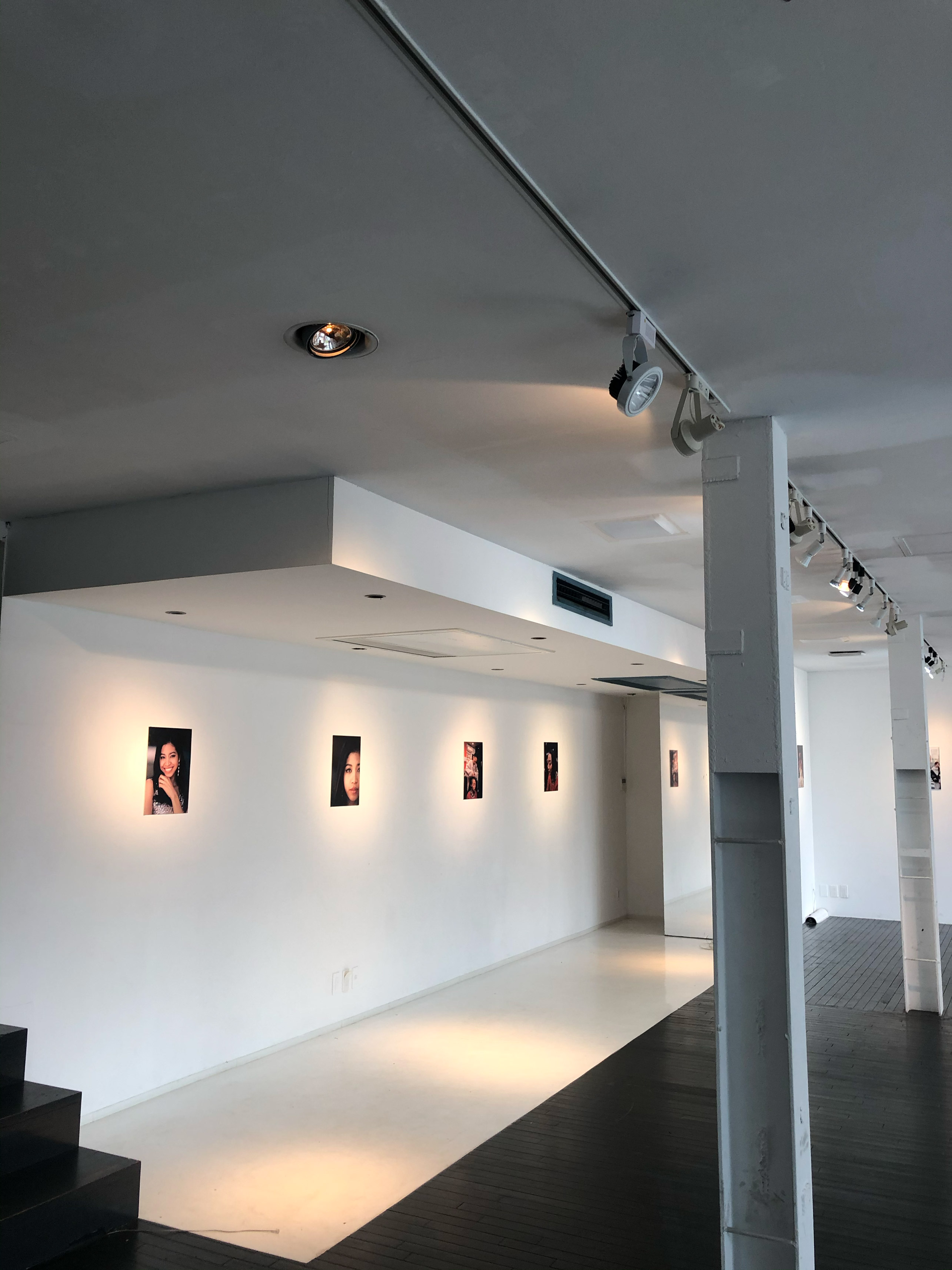 A white gallery space with five images on the wall