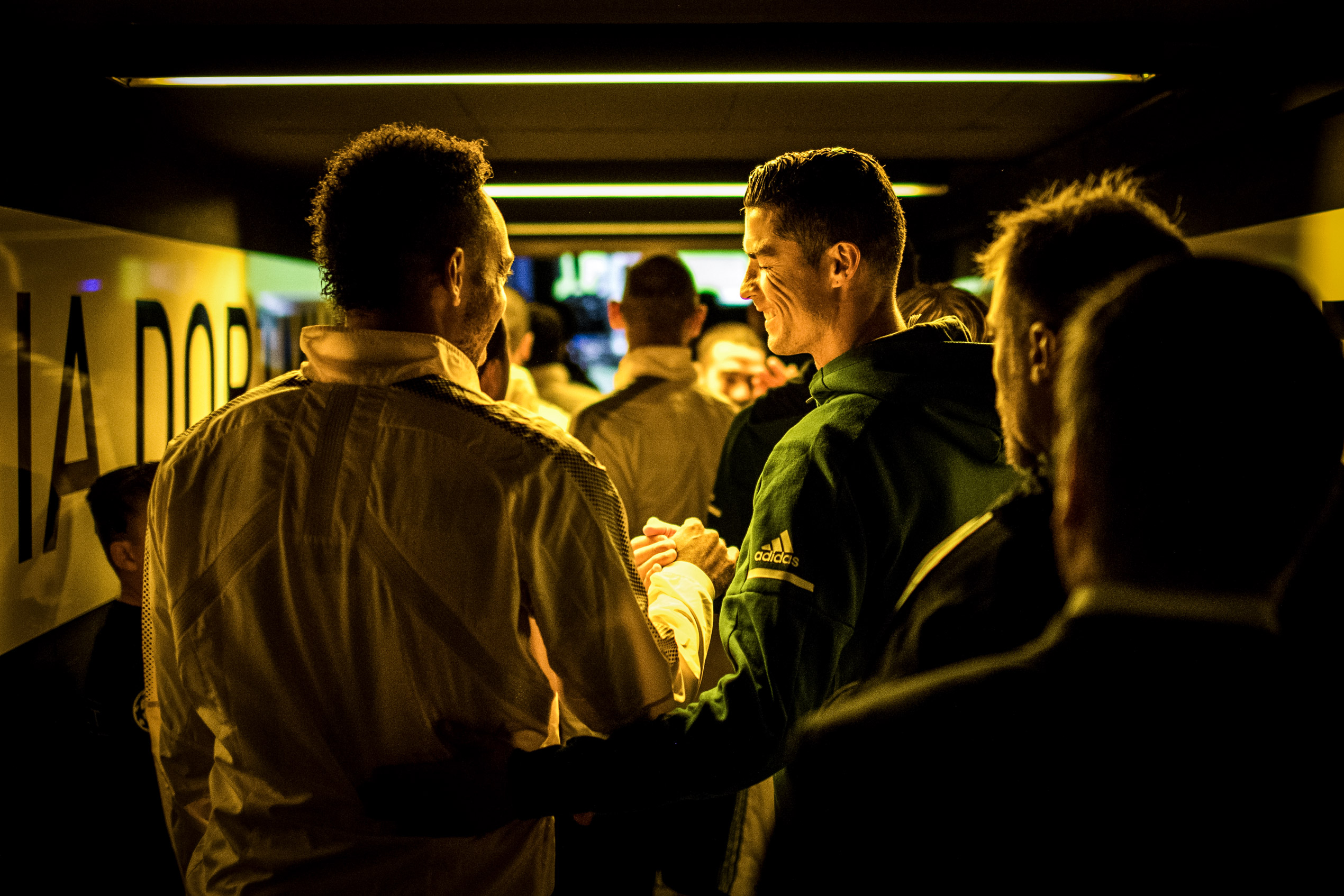 Een gouden gelamineerde foto van Vier voetbalspelers die een stadion uitlopen