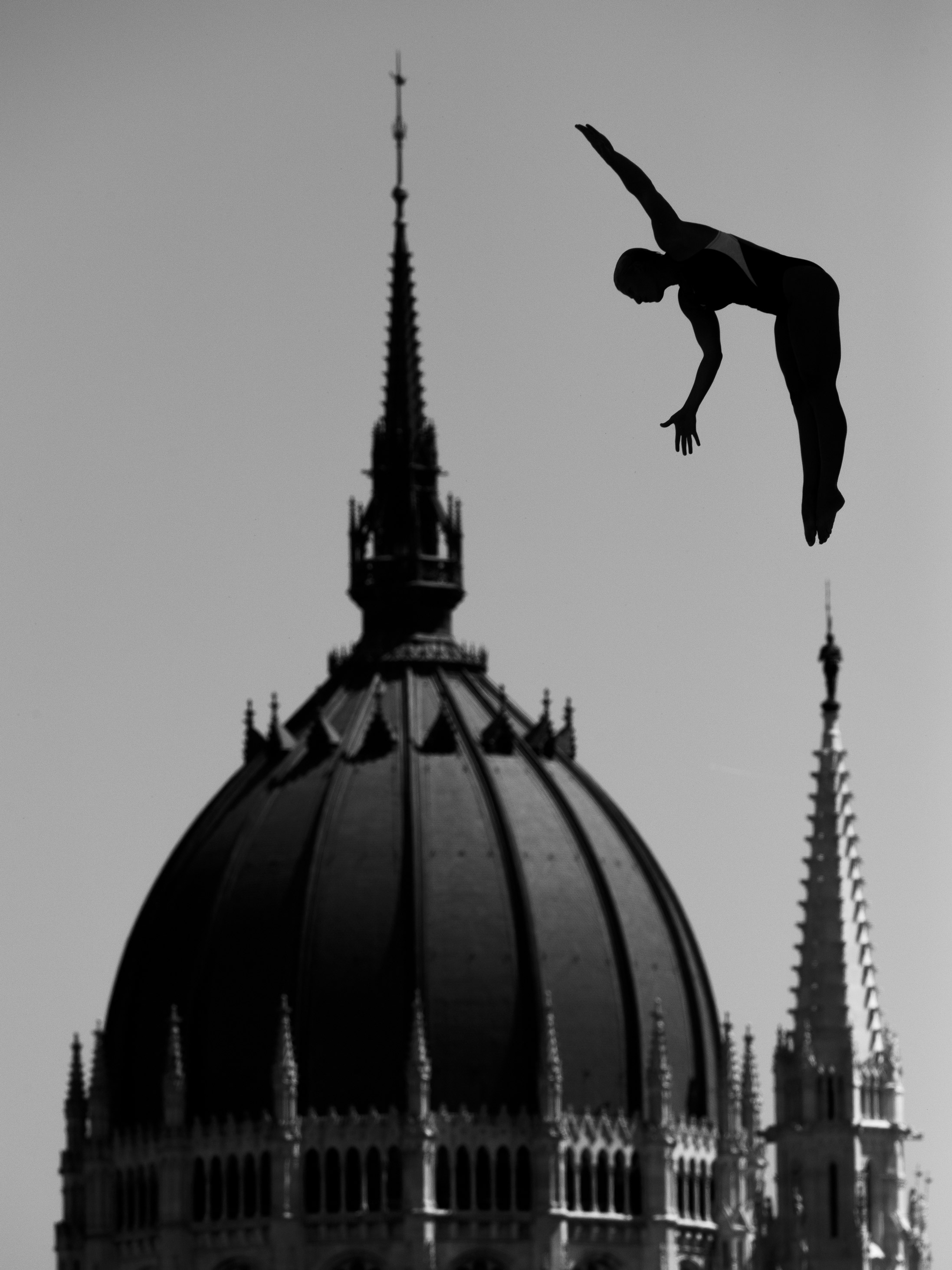 A black and white photo of a building with a person on the far right