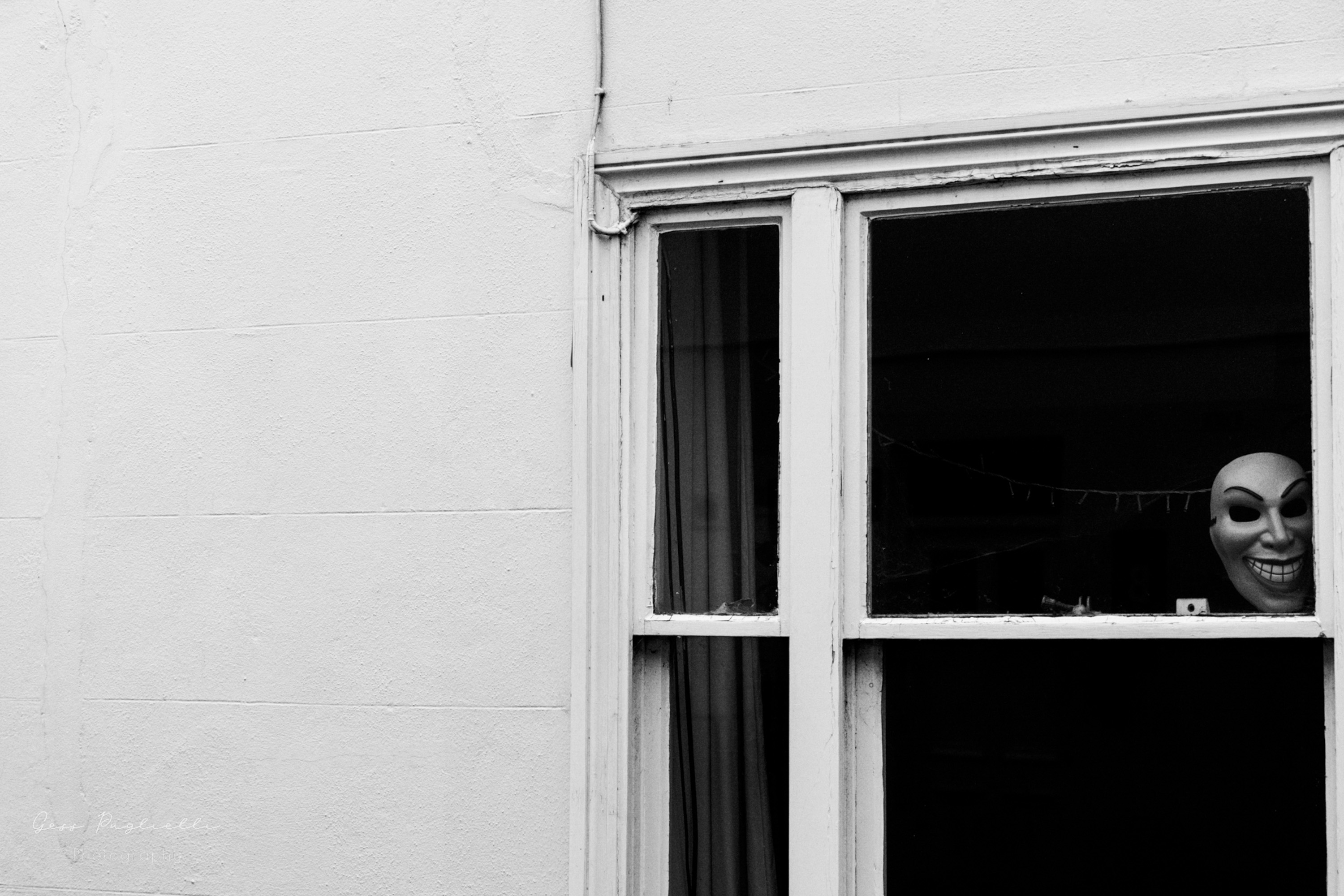 Halloween mask in a dark window 