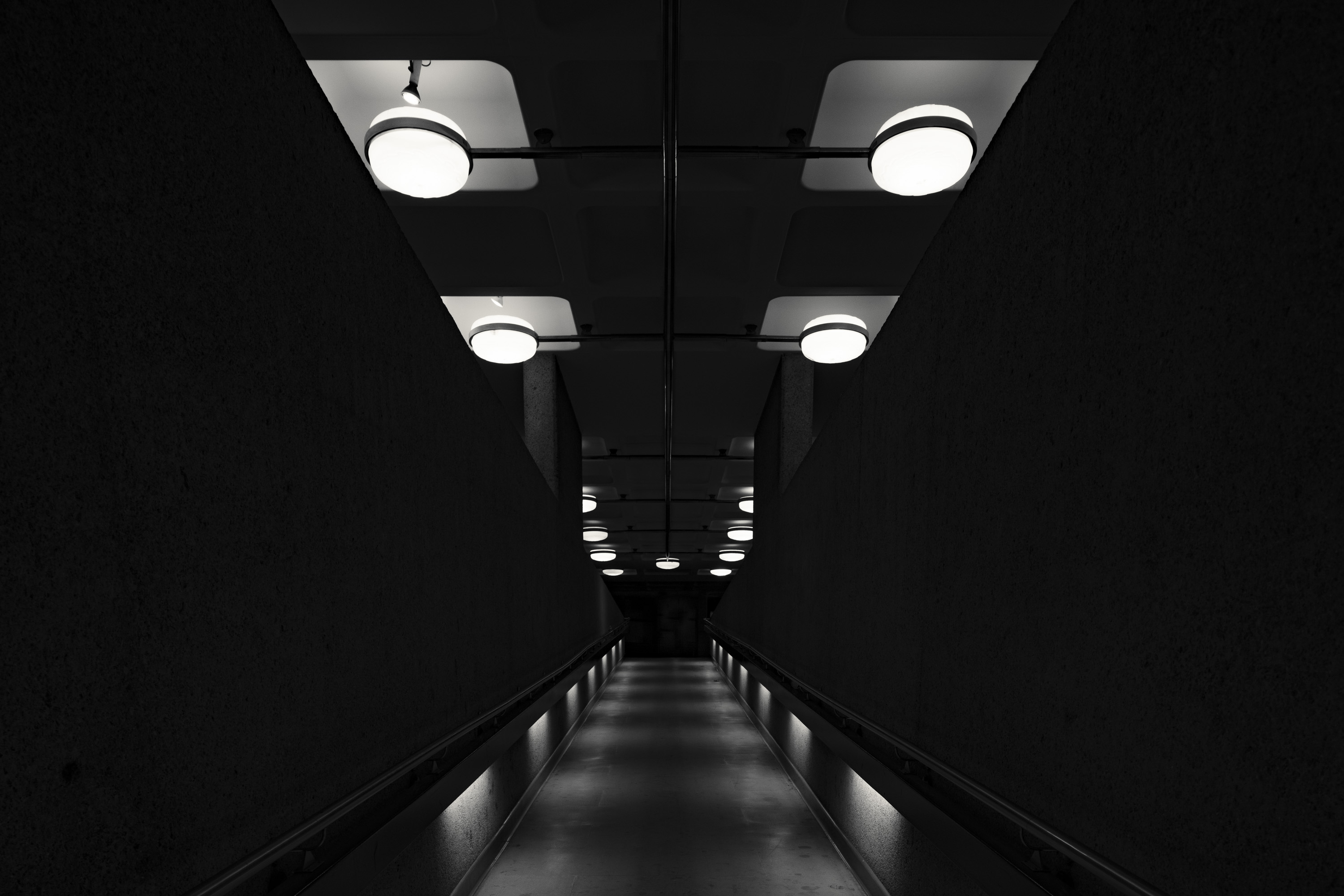Photo en noir et blanc d'un couloir faiblement éclairé