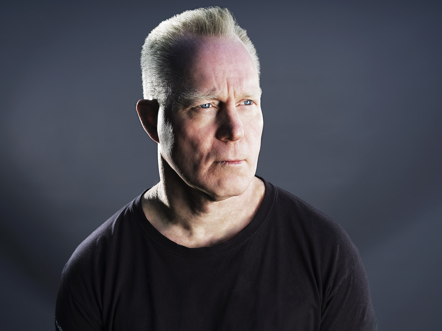 portrait of a man with sharp white hair looking serious.