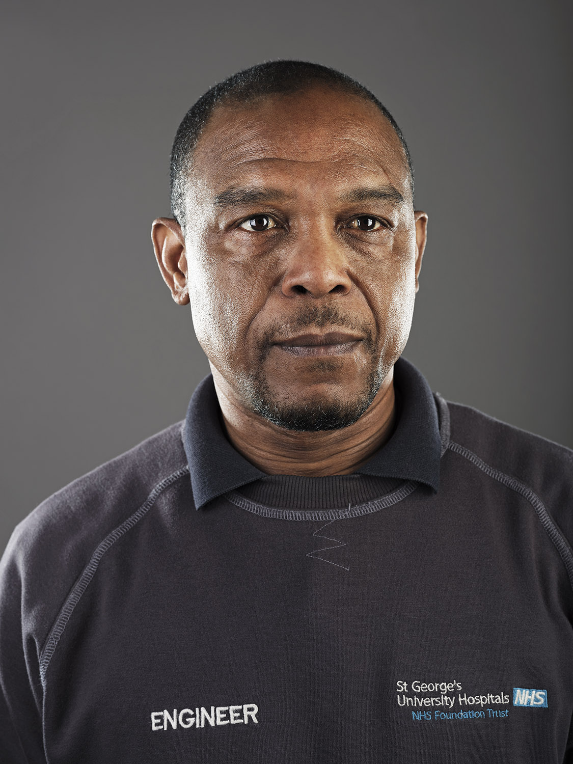 A portrait of a hospital engineer wearing a blue jumper
