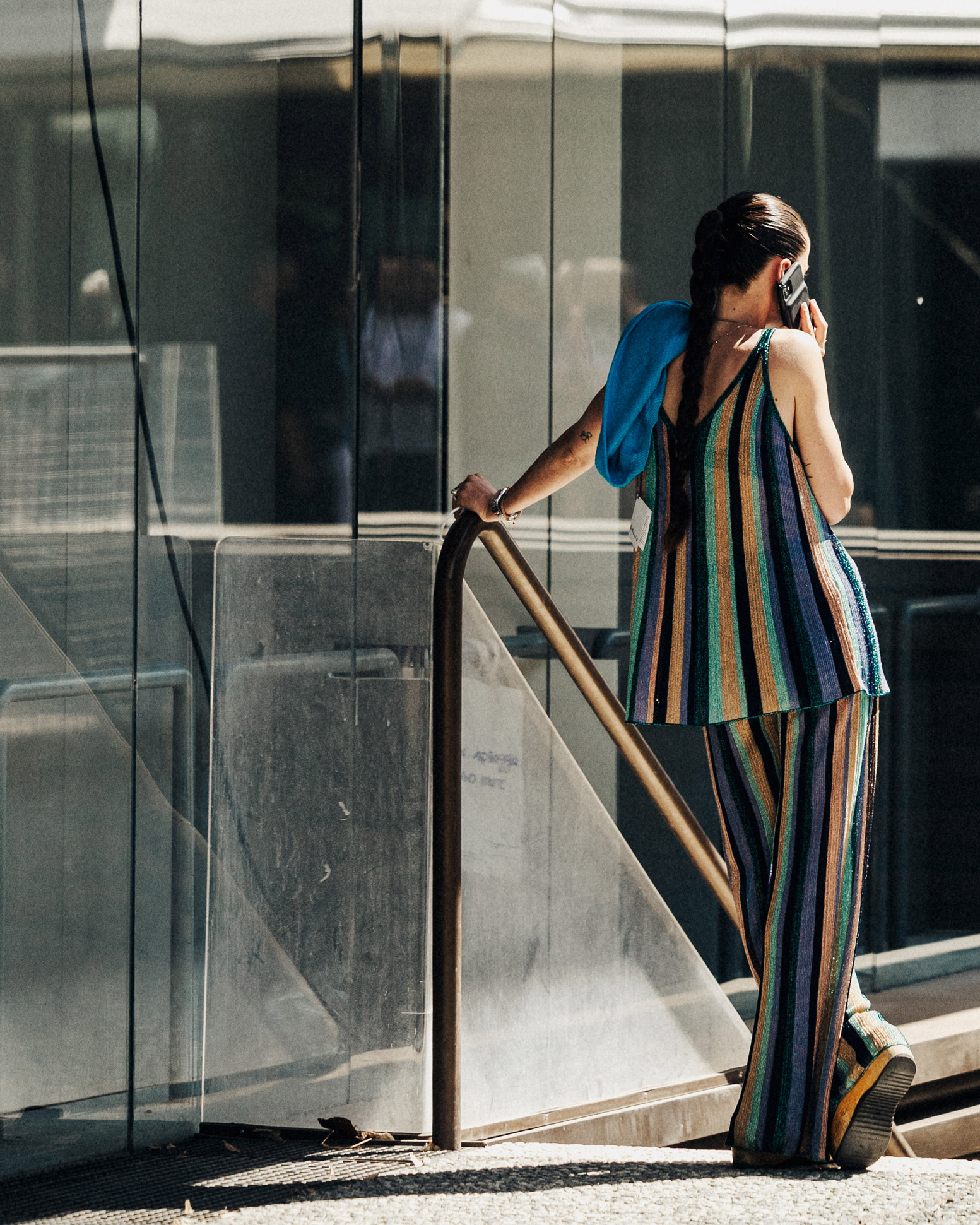 A person wearing a colourful suit, talking on a phone with their back to the camera