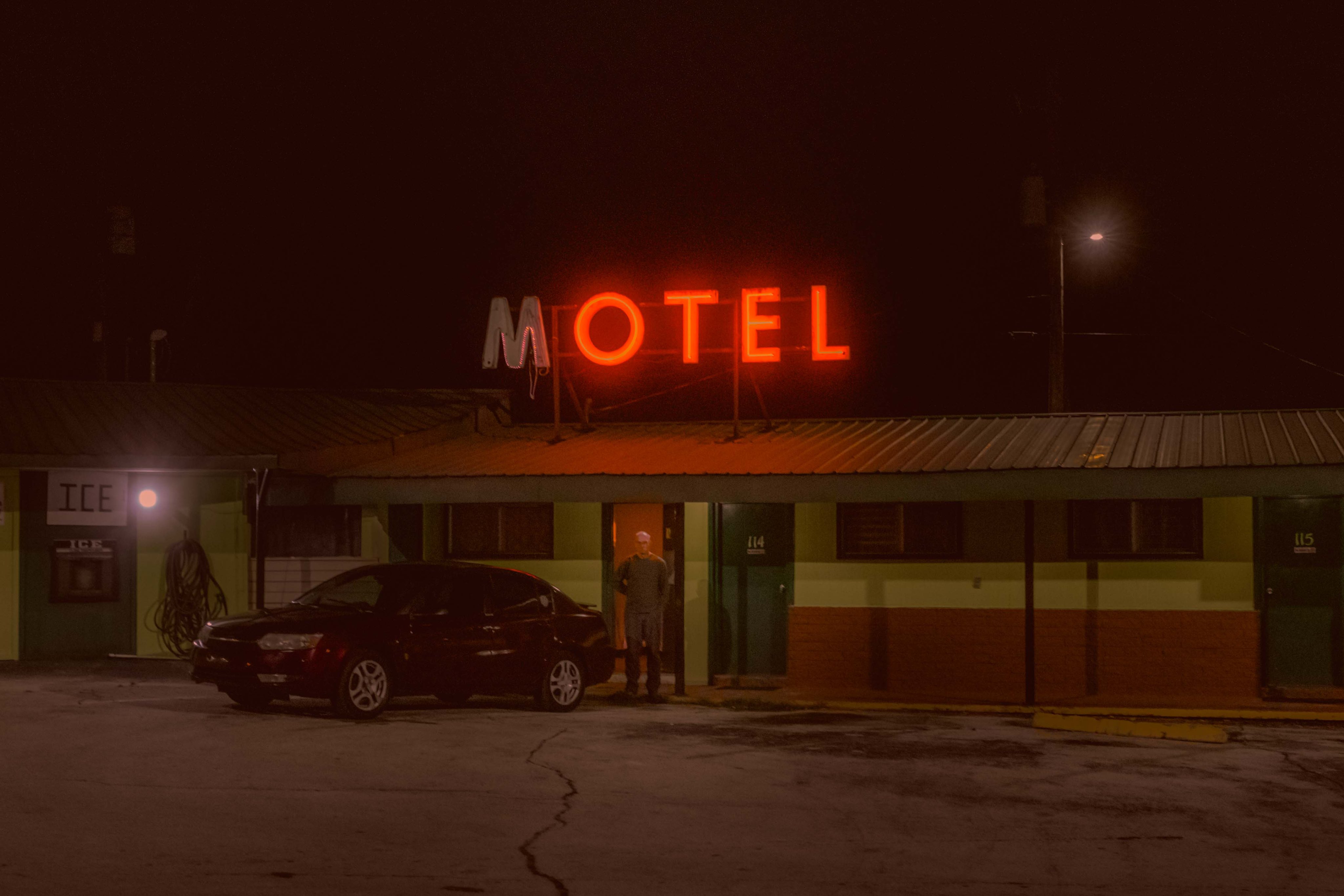 shot of the front of a motel, with a red neon sign.