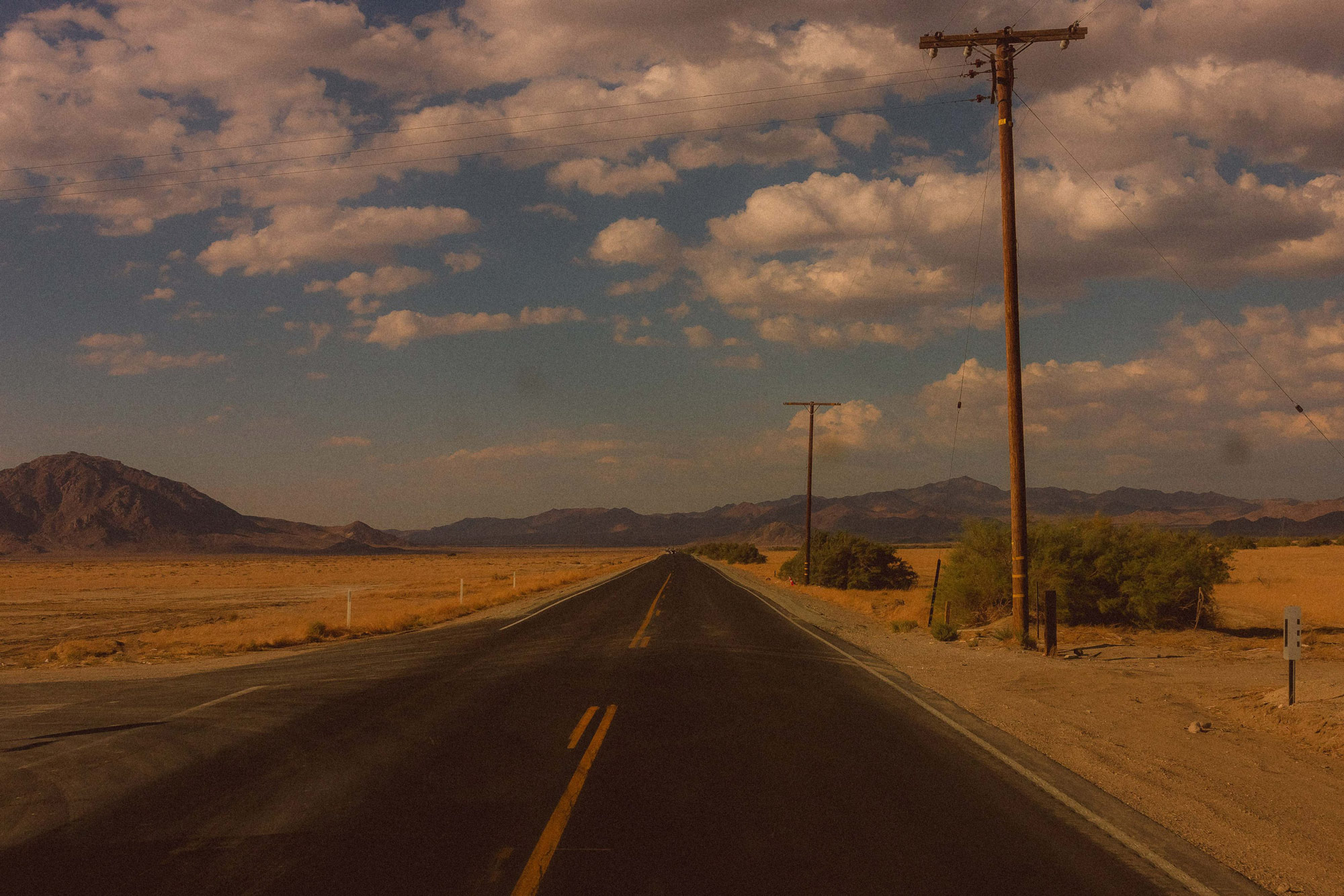 Gloomy image of a long desert desolate road in the US 