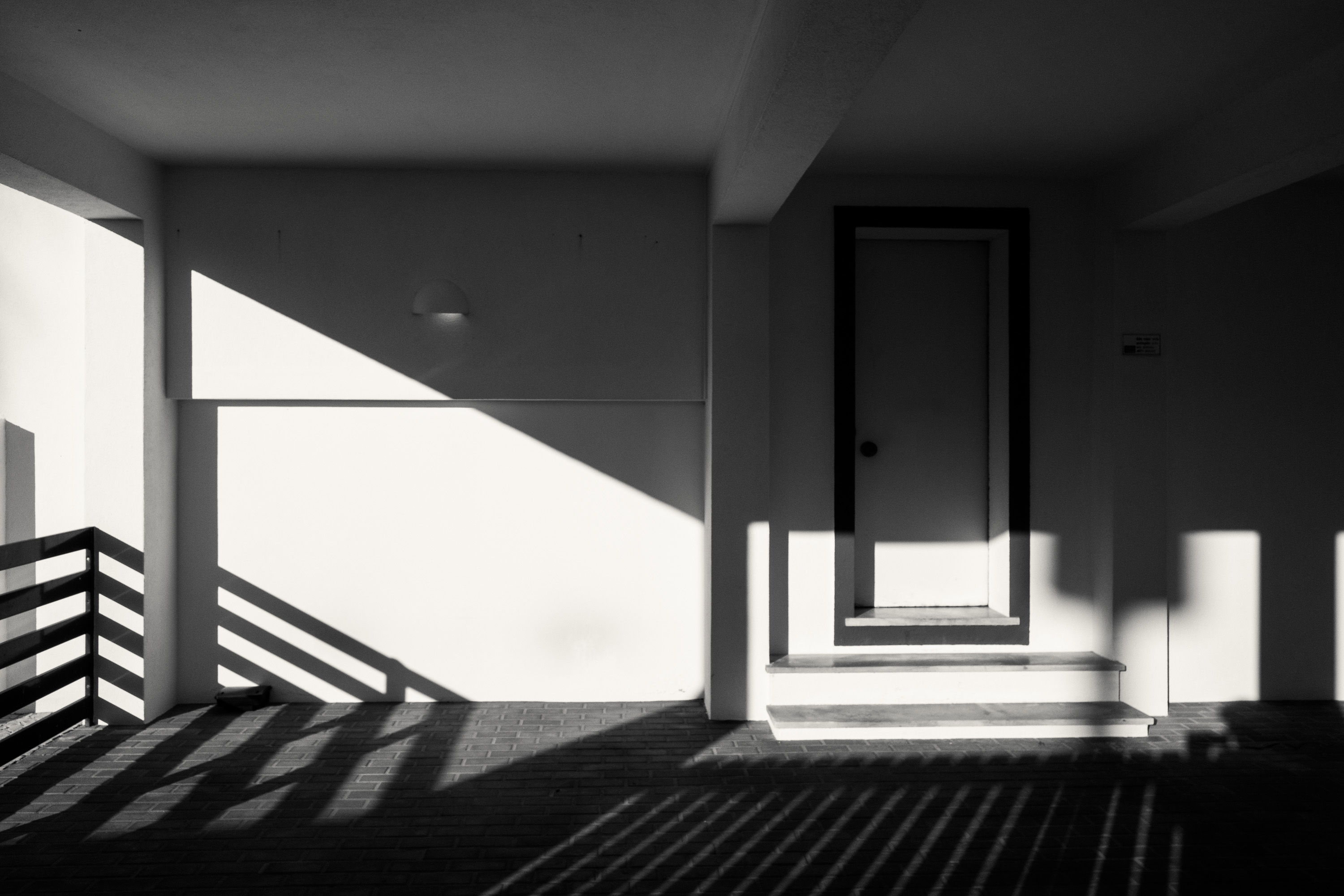 Ein Schwarz-Weiß-Bild eines Gebäudes mit Schatten, die geometrische Formen bilden