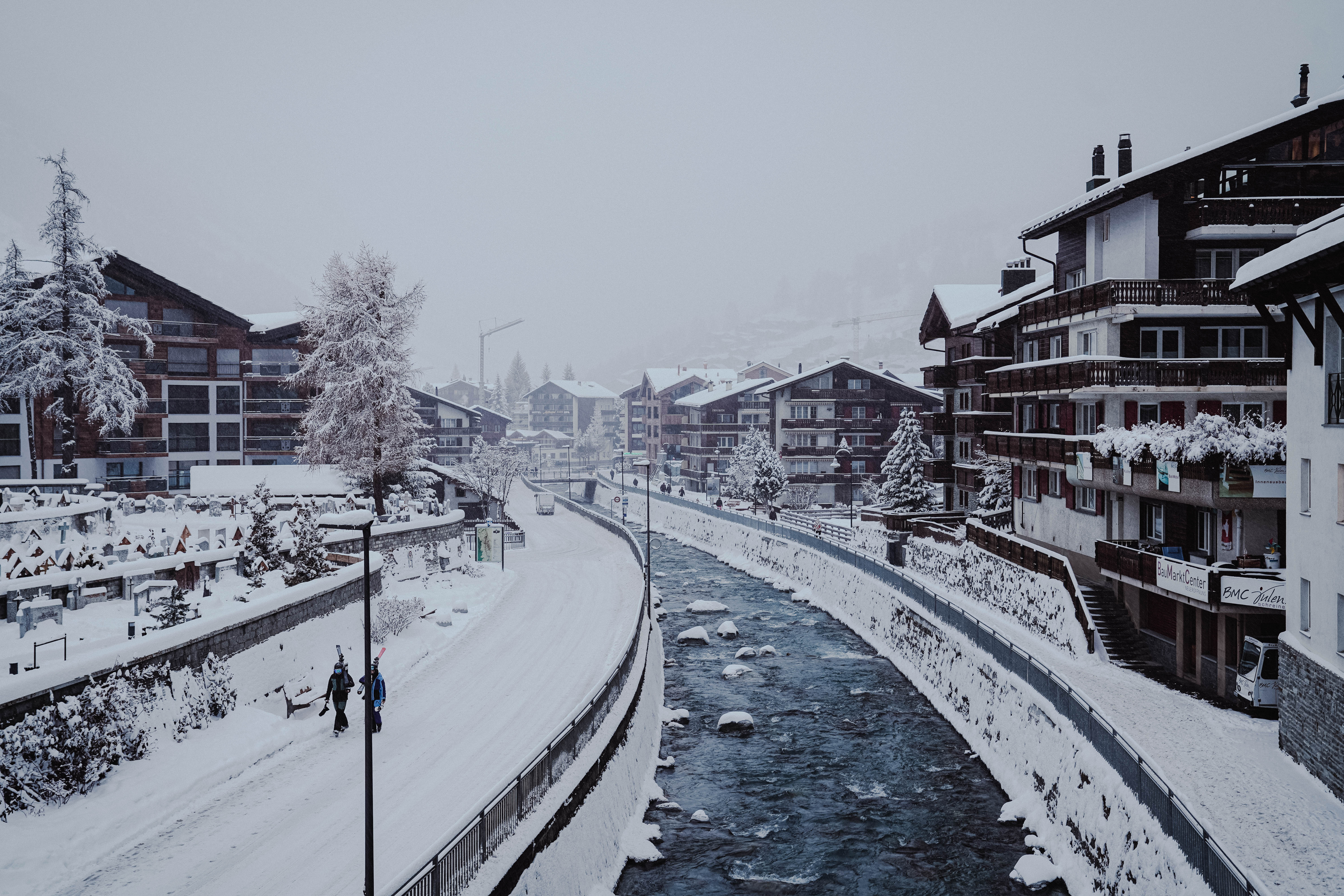 Ein eisiger Fluss fließt durch das Dorf Zermatt, Schweiz