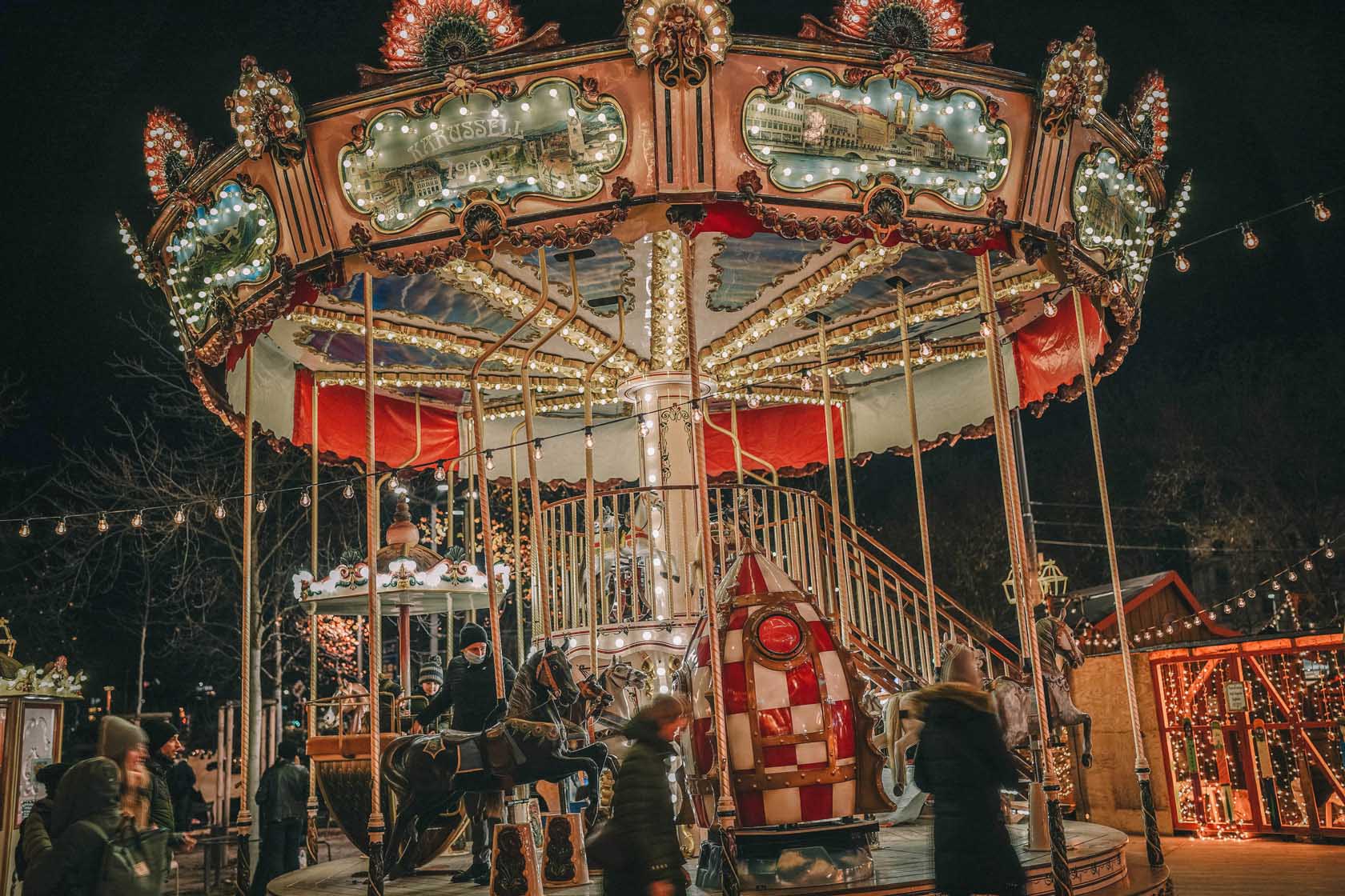 A fairground carousel at night with children on it 