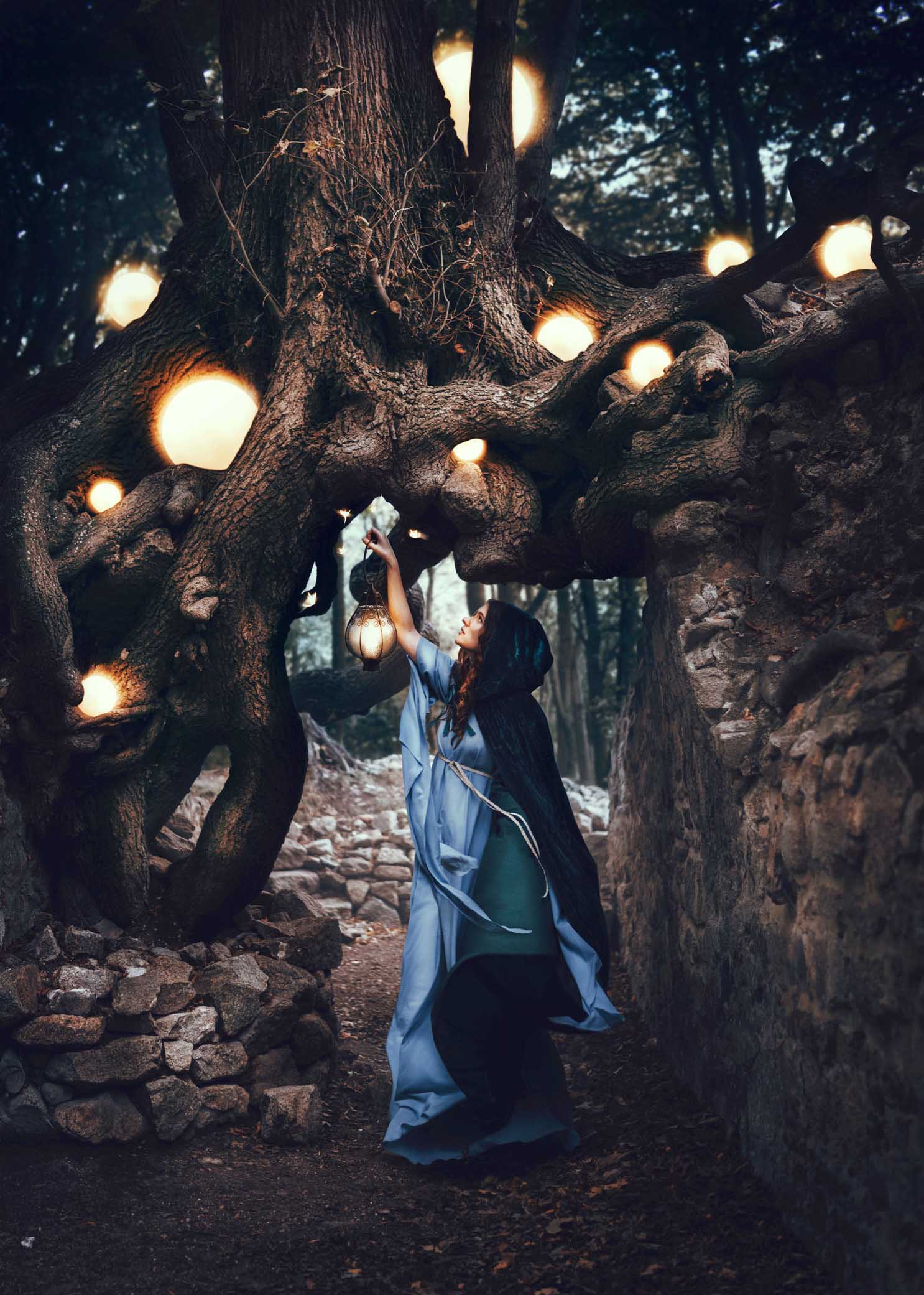 Eine Frau mit einem blauen Umhang steht umgeben von mysteriösen Lichtkugeln in einem Wald