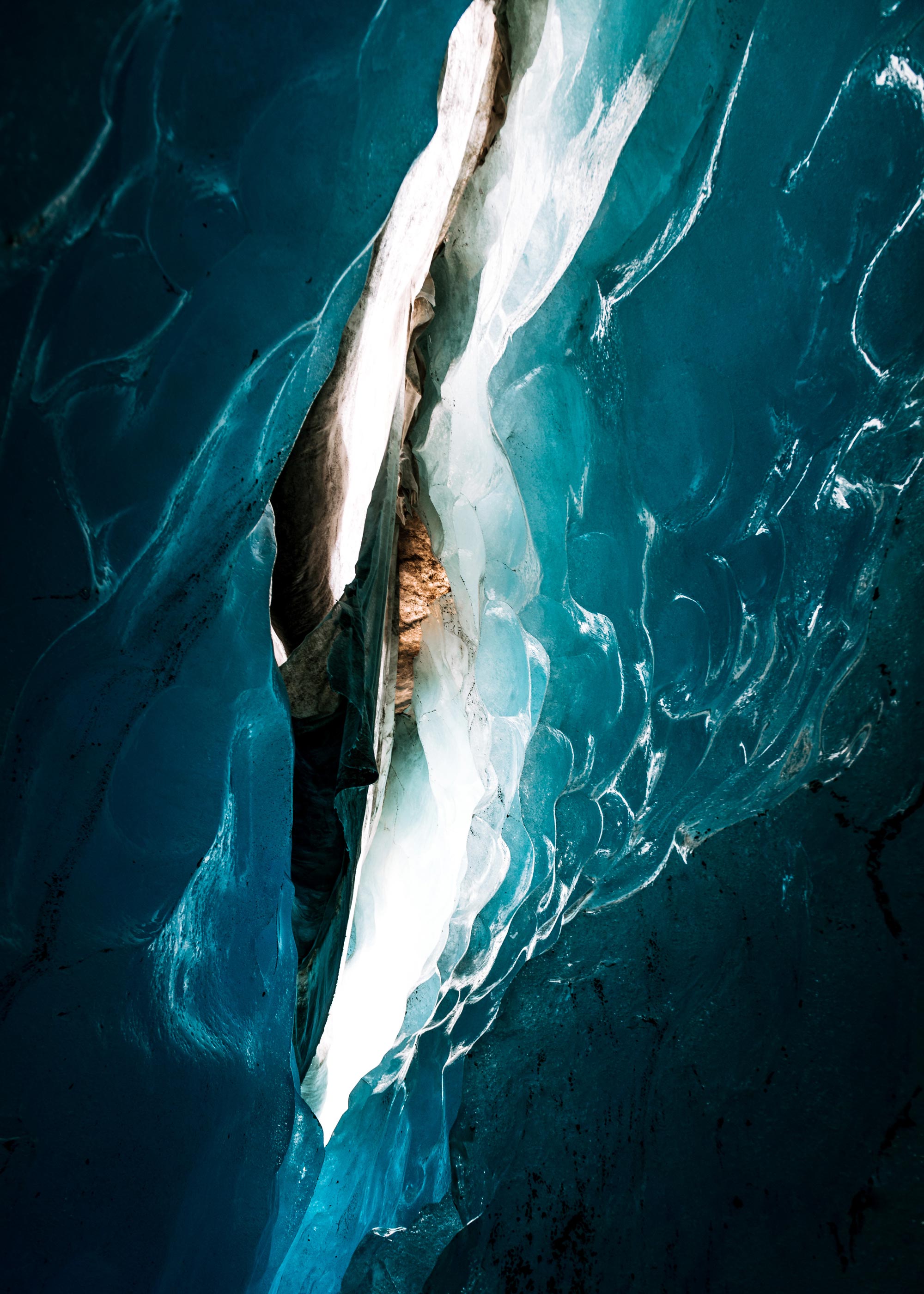White light shines through a crevice in an icy cave