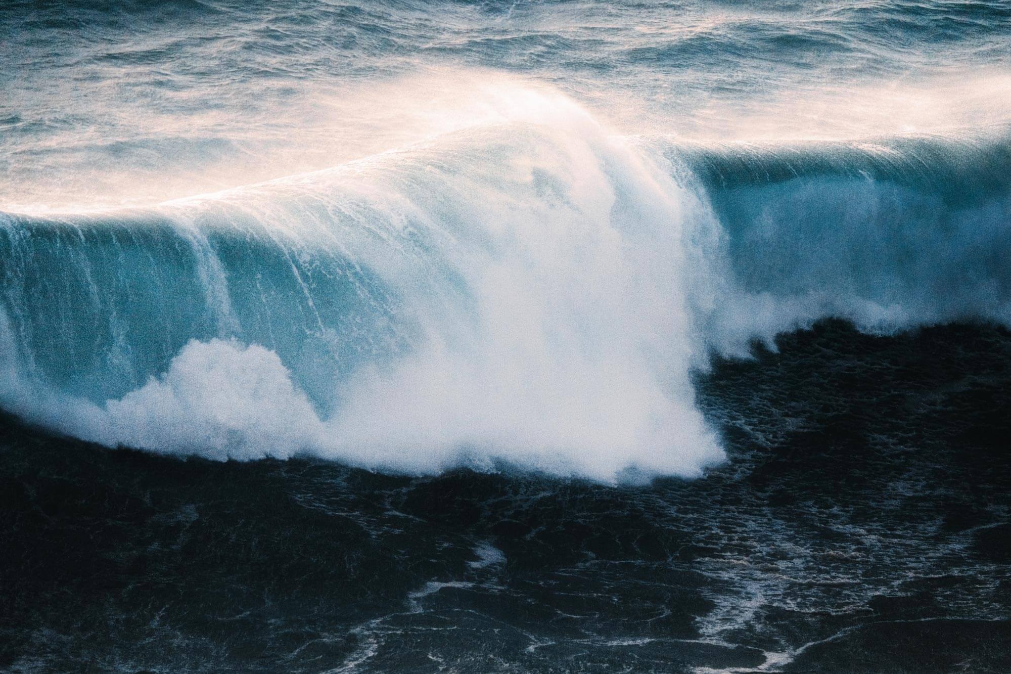 A close-up picture of a wave crashing in the ocean