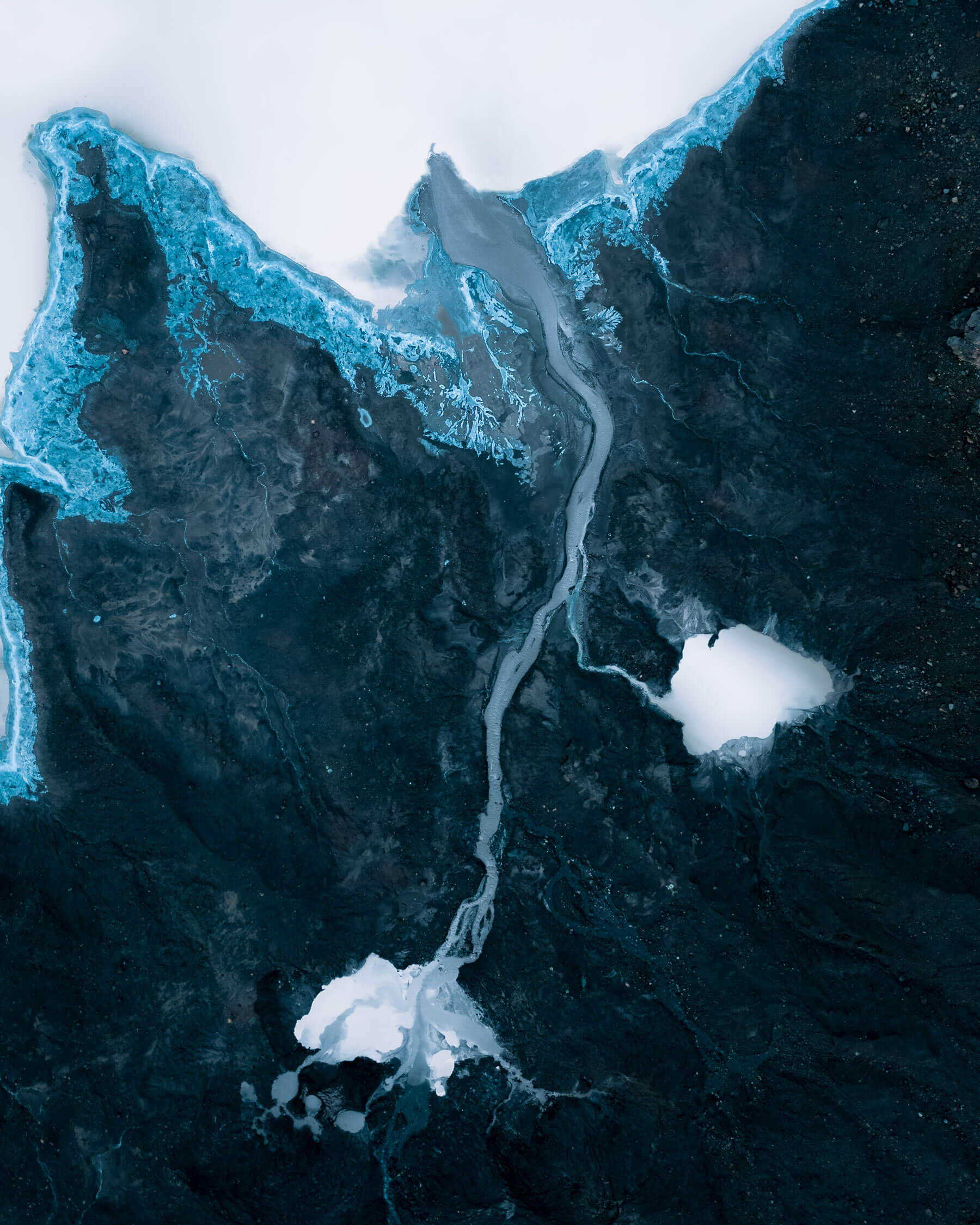 A big iceberg losing two smaller icebergs crossing each other on the ocean