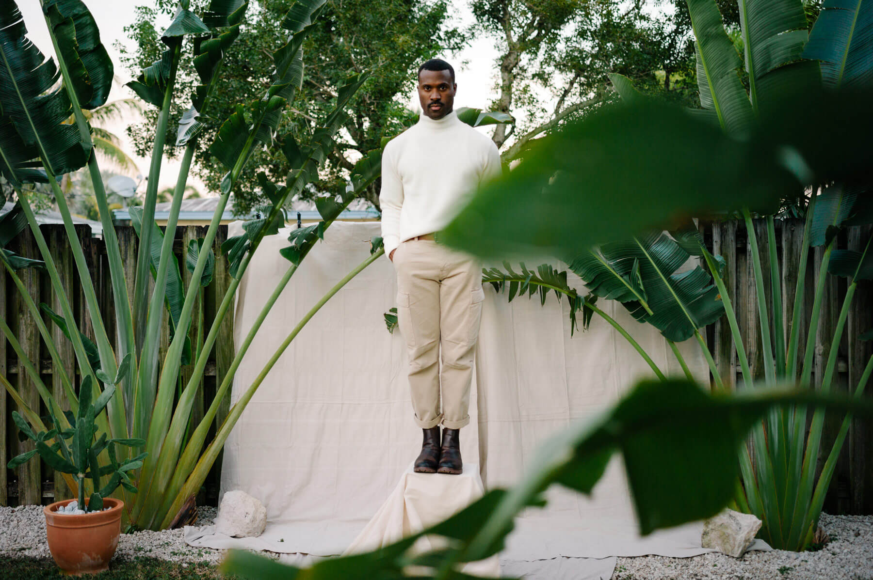Man standing on a box in a garden