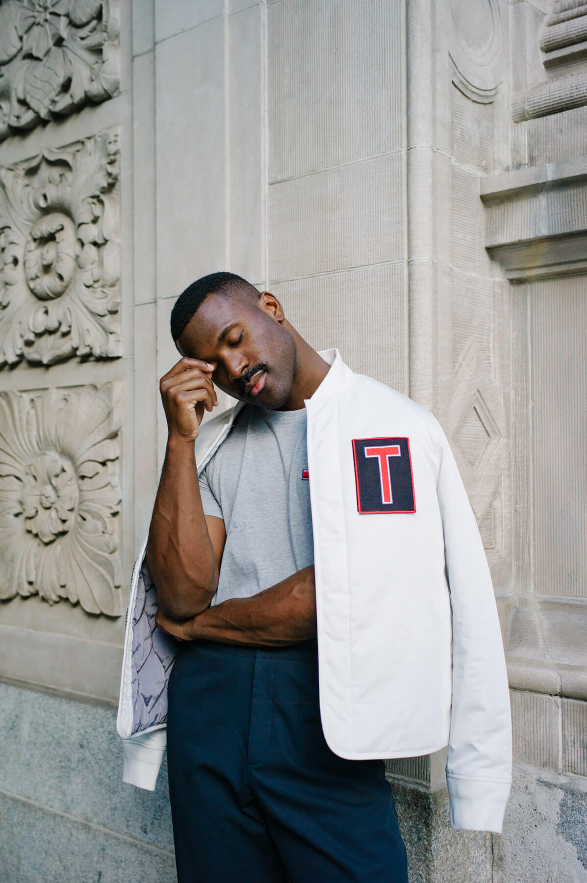 A thoughtful man with a white jacket over his shoulders
