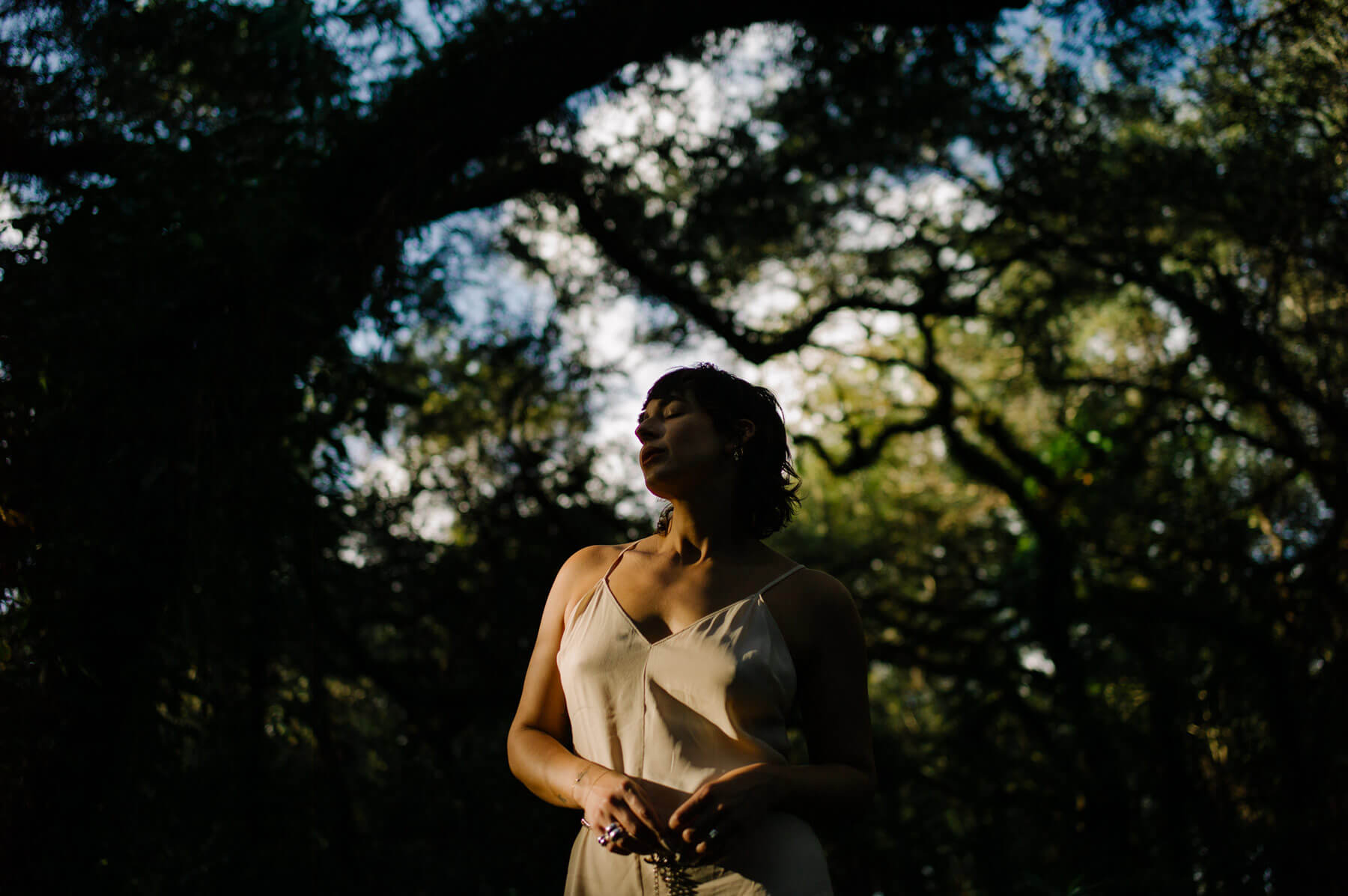 A lady posing for a photo in the woods